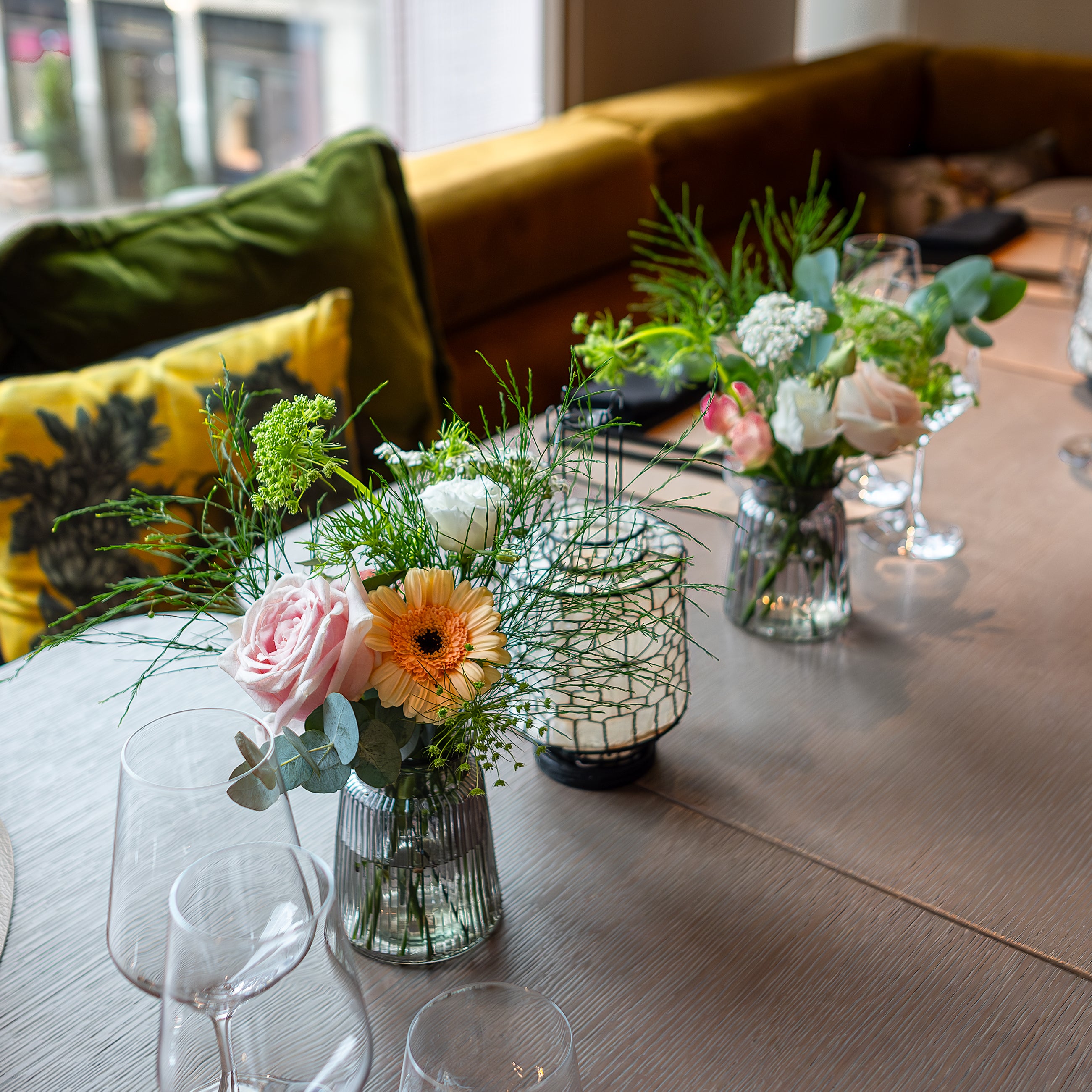 Elegant small table floral arrangements, a delicate combination of pink roses, peach gerberas, and lush greenery, perfect for adding charm and sophistication to this birthday event setting - Amaranté London.