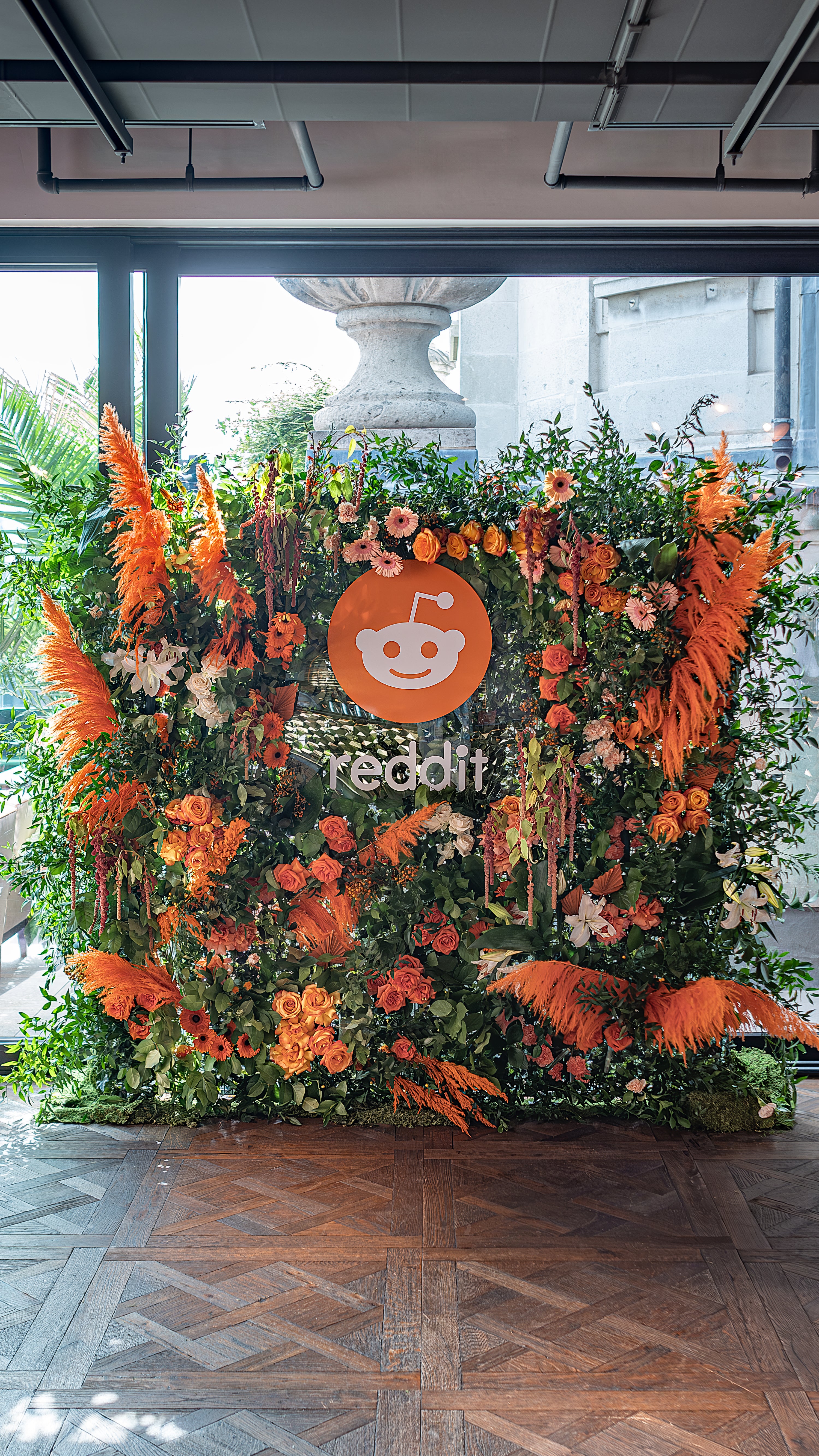 Amaranté crafted a bespoke floral wall in lively shades of orange and green for Reddit's event, brilliantly highlighting their distinctive brand colors.