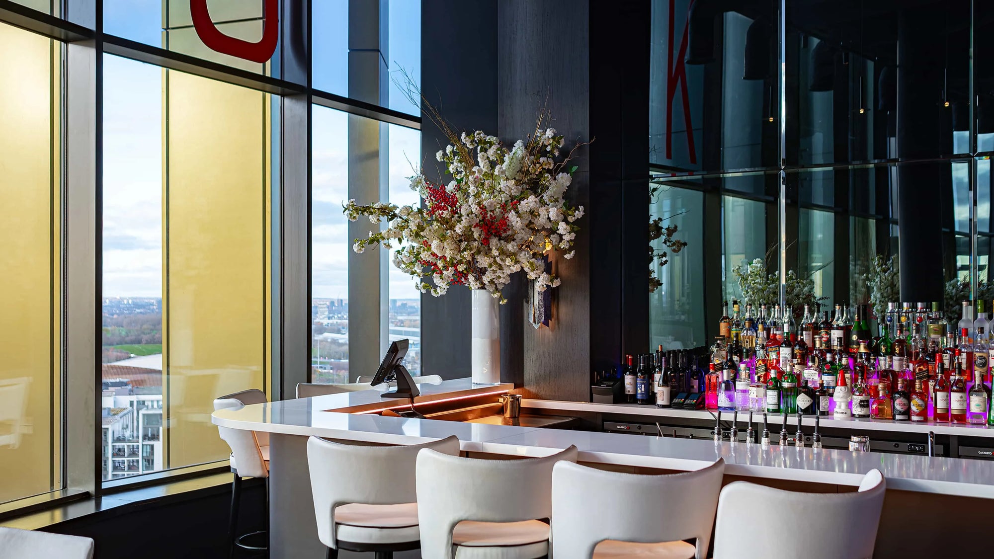 The bar area at STK Steakhouse with a bespoke Christmas floral arrangement in a white vase - Amaranté London