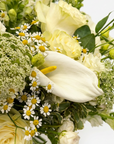 Close-up detail of Selene bouquet showing white calla lily with yellow stamen, delicate chamomile daisies, cream roses and textured green trachelium in sophisticated arrangement - Amaranté London