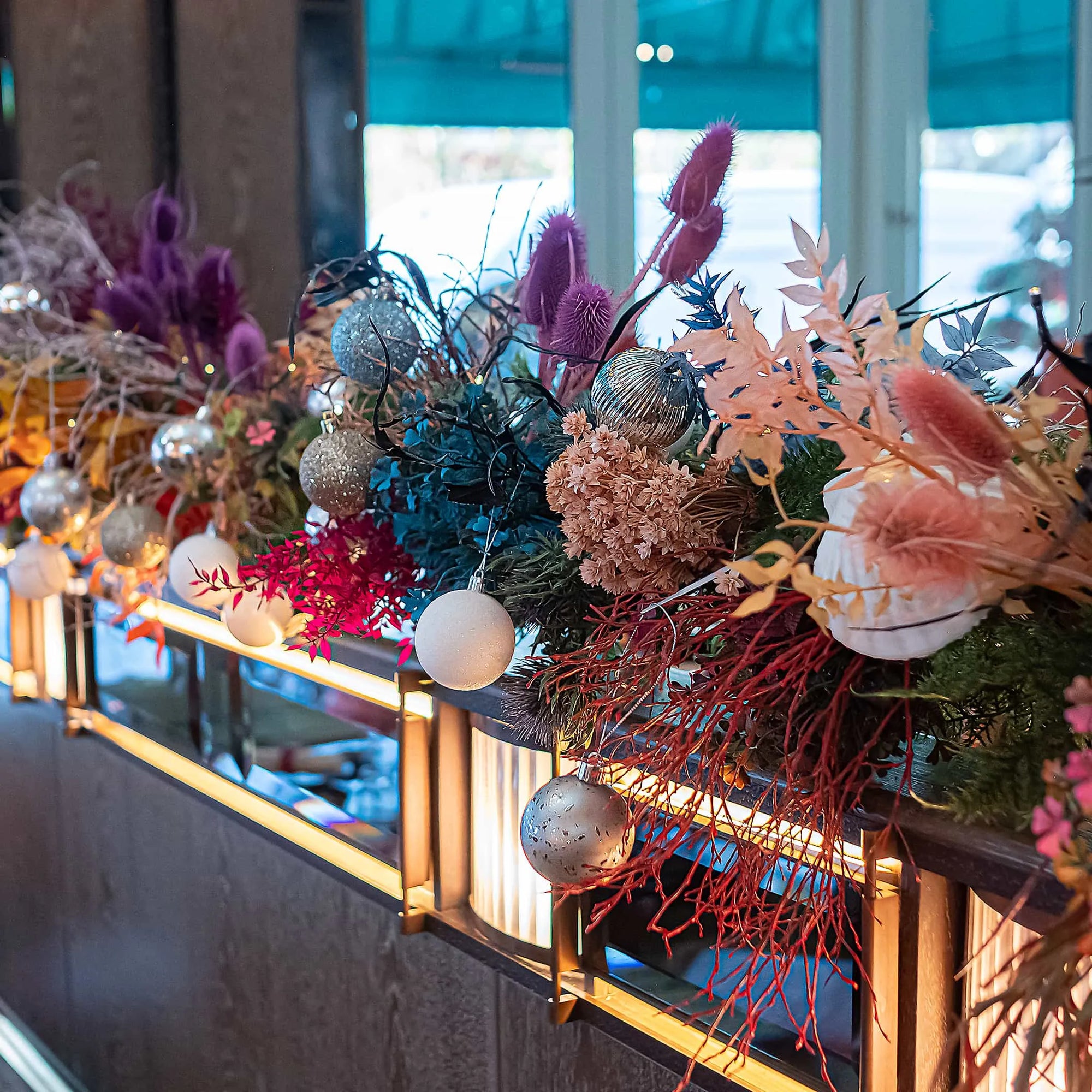 Christmas floral décor by Amaranté London inside Sexy Fish Restaurant, showcasing a stunning mix of pink, blue, and white flowers with festive baubles, enhancing the elegant interior with a vibrant fresh marine theme.