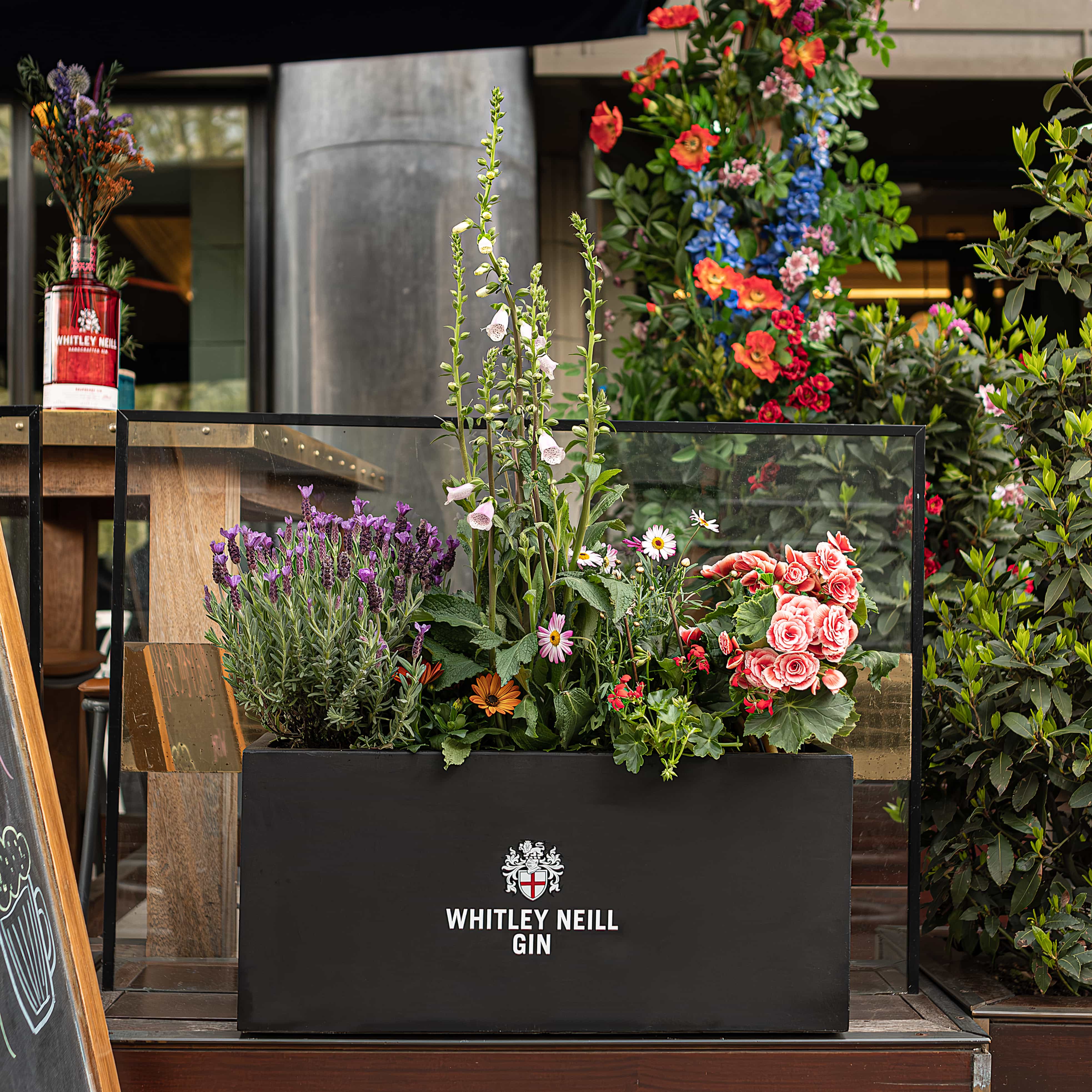 Exterior bespoke floral planters with client Whitley Neill’s logo, installed at Smith & Whistle’s terrace.