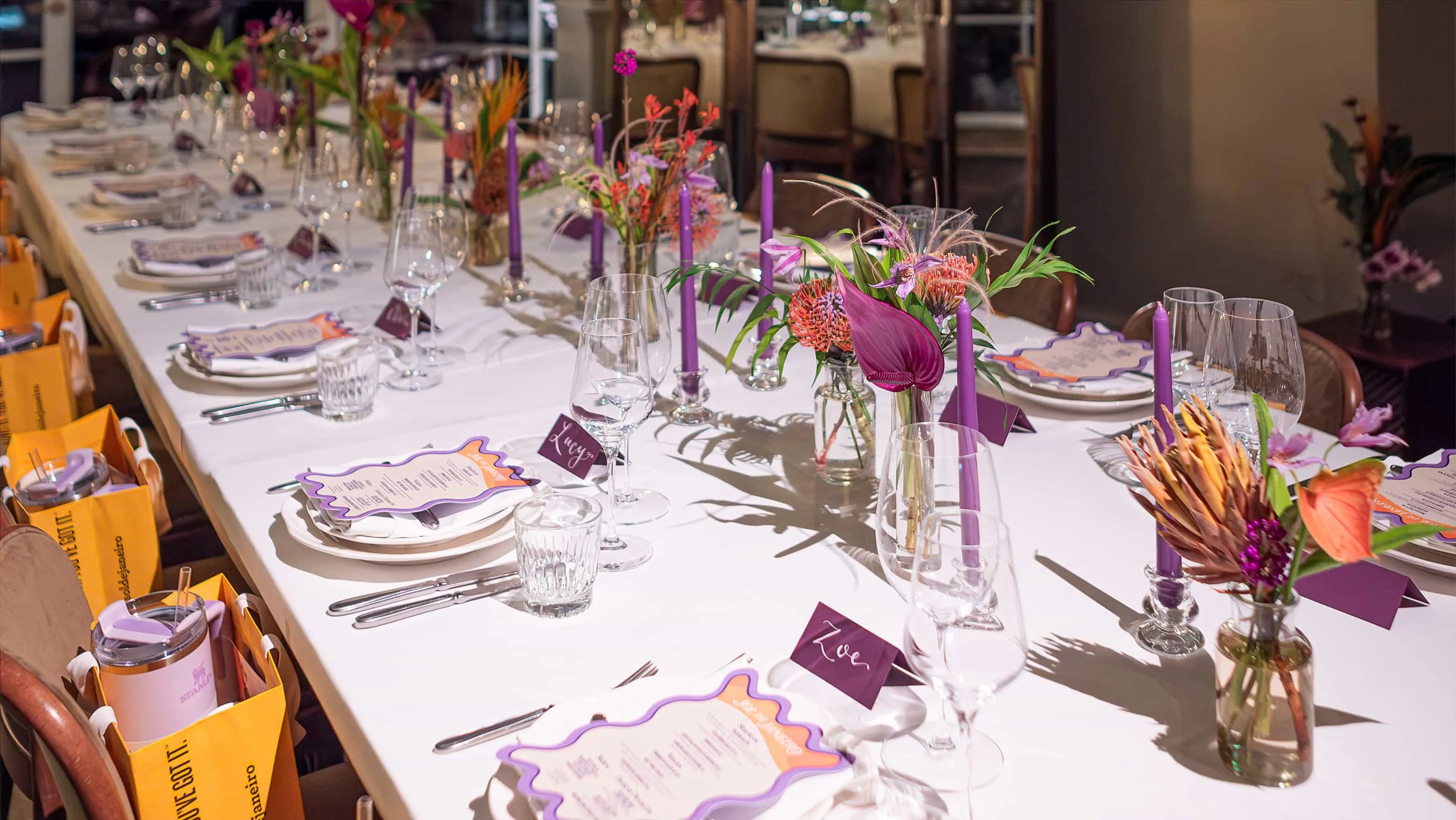 Elegantly set dining table at Maine Mayfair restaurant with Amaranté London's floral centerpieces, fine glassware, and personalized place settings for an exclusive Sol de Janeiro event.