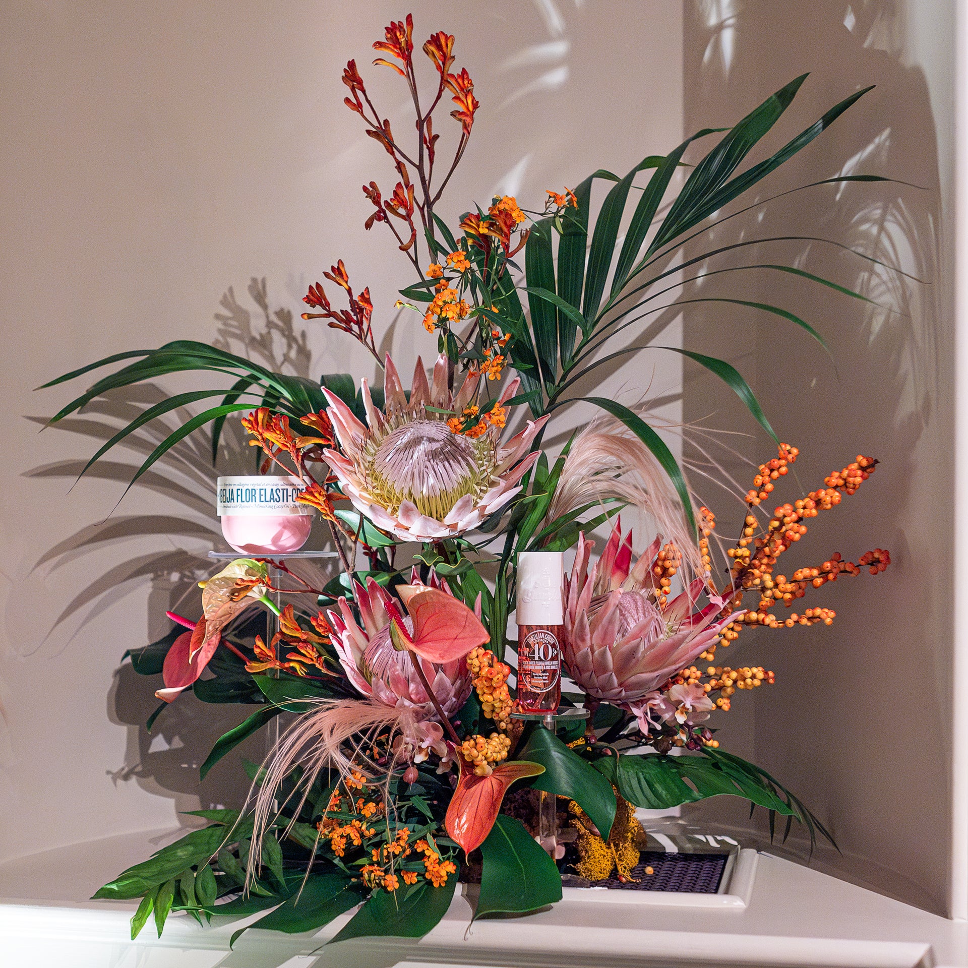 Statement floral installation featuring king protea, anthurium, tropical foliage and seasonal berries, created for Sol de Janeiro, London