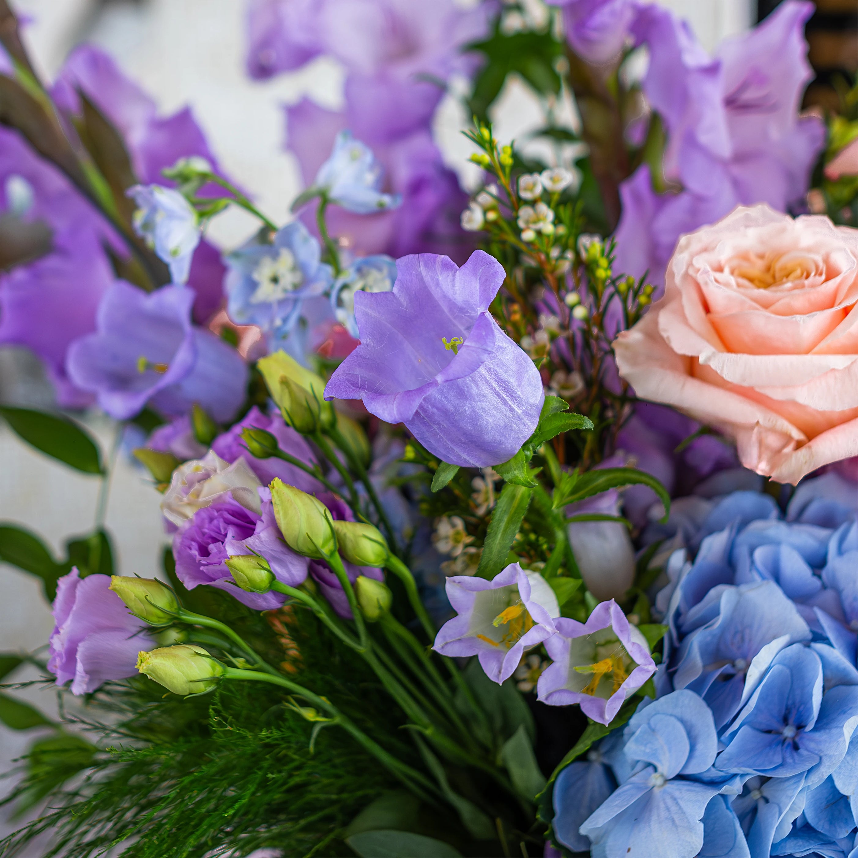 Close-up of a luxurious floral party decoration bouquet by Amarante London for a birthday event at Sushi Samba. The bouquet features blue hydrangeas, pink roses, and purple lisianthus, capturing the elegance and vibrant colour palette designed for the occasion.