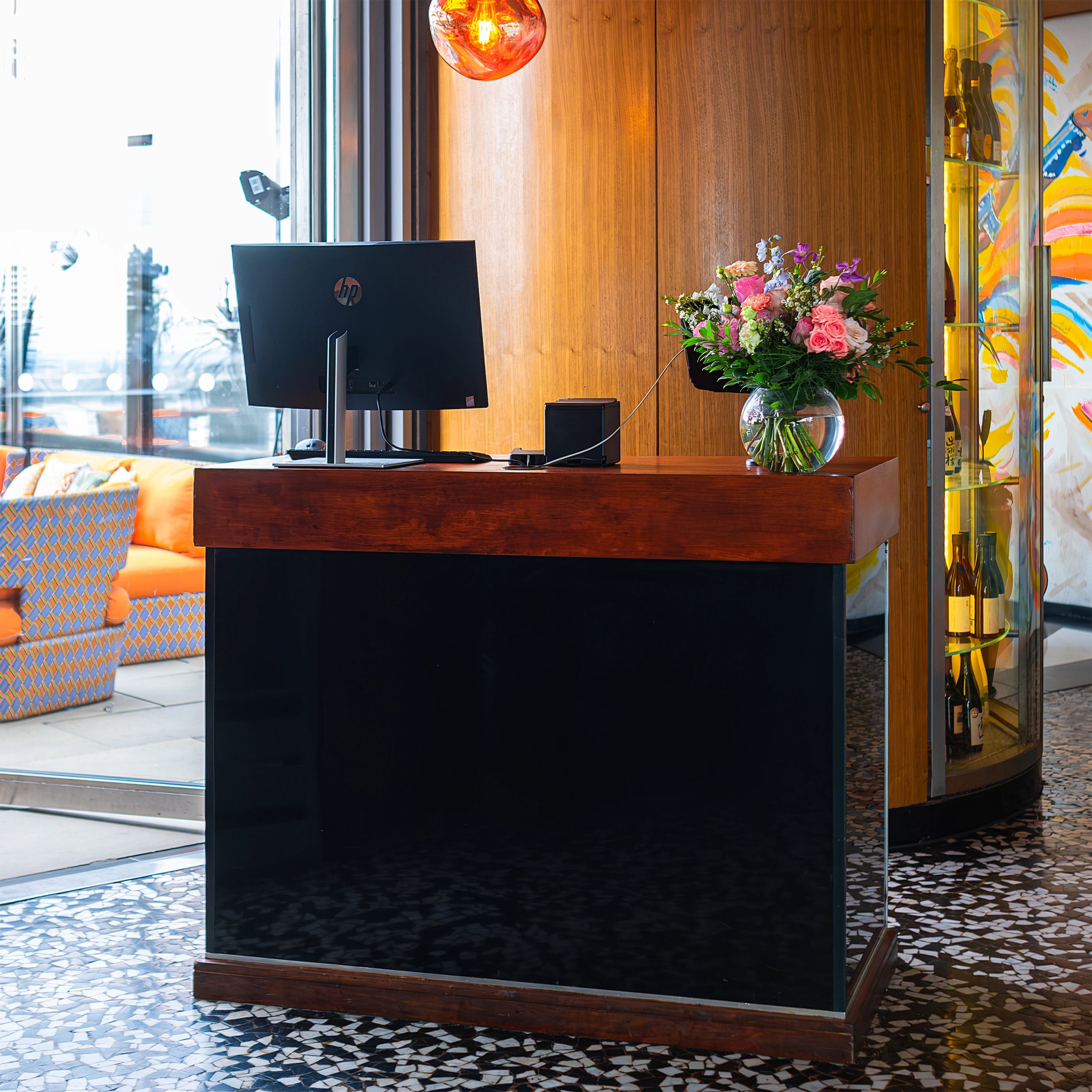 A beautiful floral arrangement, part of the floral party decorations, by Event Florist Amarante London, is placed at the reception desk of Sushi Samba for a birthday event. It features pink roses, white blooms, and lush green foliage, adding a touch of elegance and a welcoming ambience to the space.