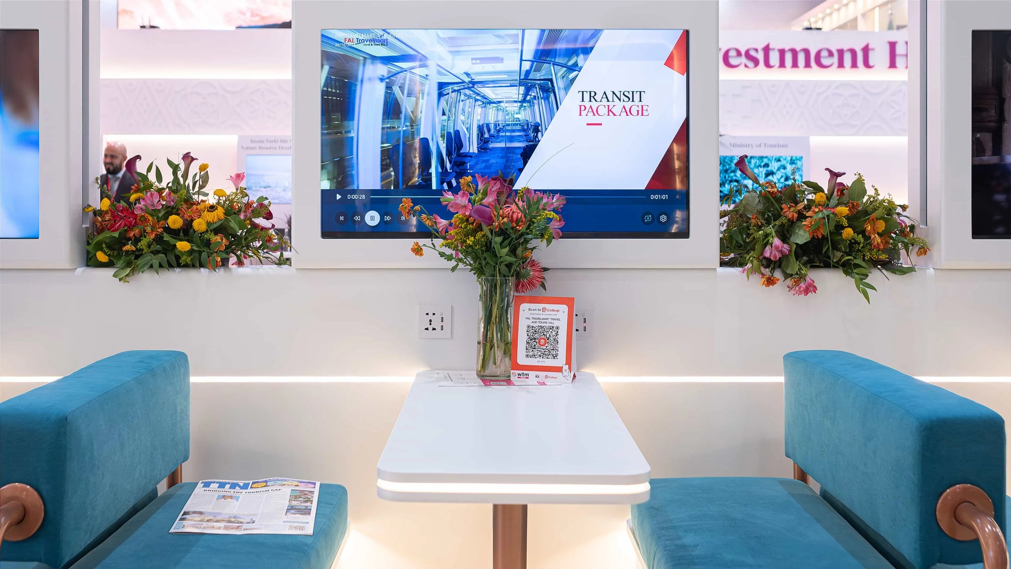 Charming floral displays and bright pink and orange blooms by Amaranté London at WTM complement the contemporary meeting setting of a booth.