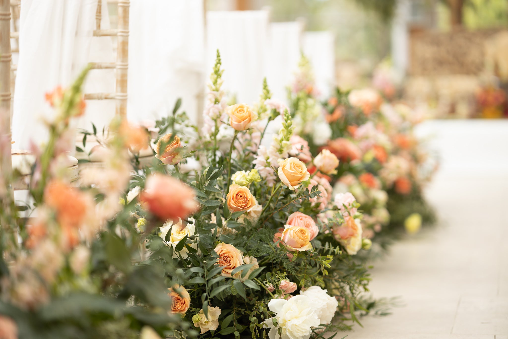 Close-up detail of natural floral arrangement featuring peach roses and mixed seasonal blooms with organic styling - Floral Design by Amaranté London