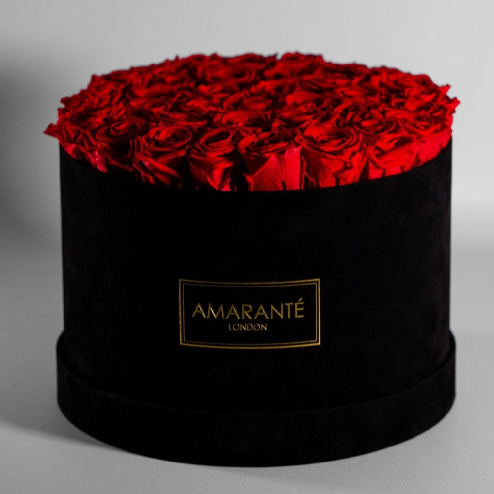 Divine red Roses in a modish black round extra large box. 
