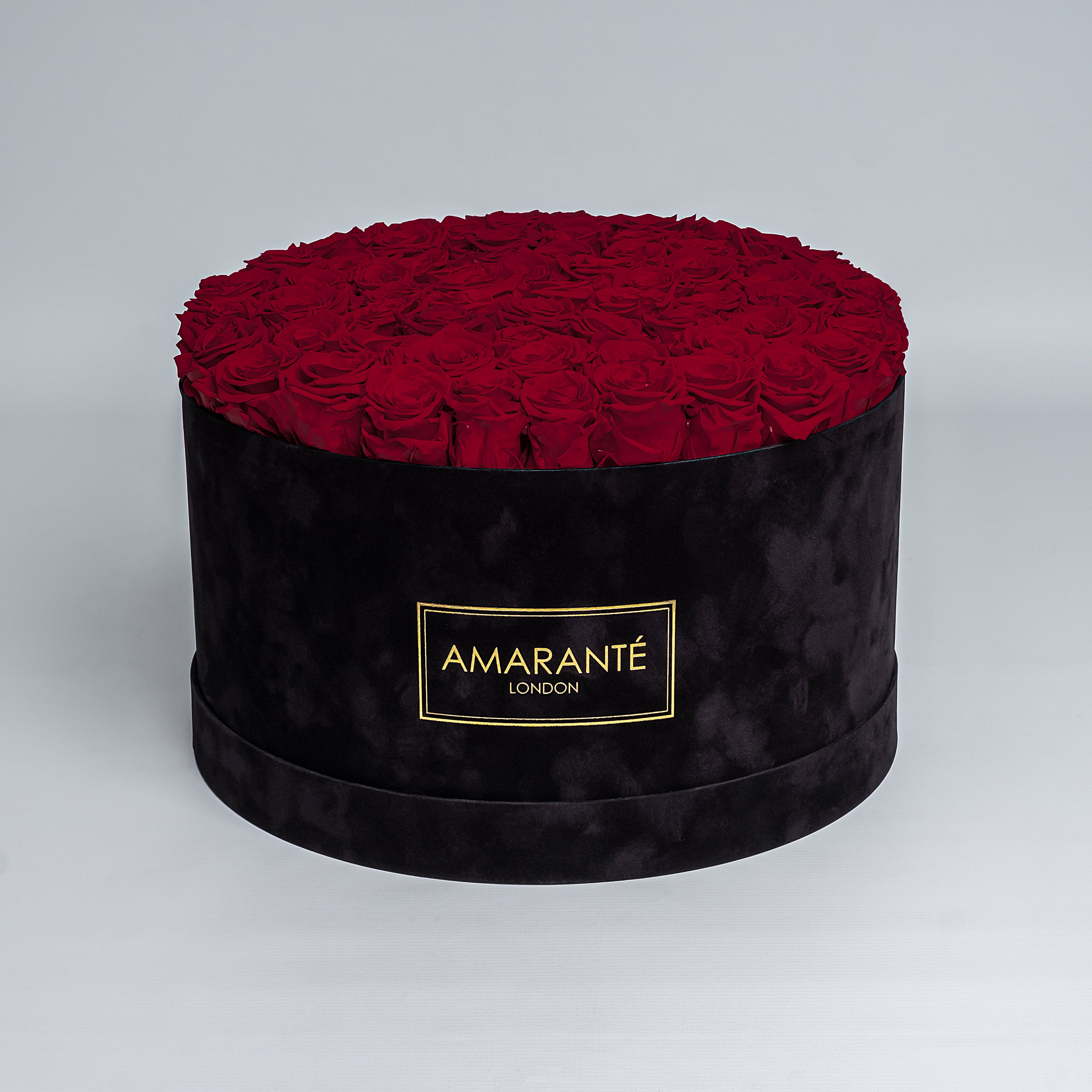 70 Exquisite dark red infinity roses elegantly arranged in a stylish black deluxe suede round rose box. Perfect for expressing timeless love and affection to family, friends and loved ones. Available for free UK delivery.