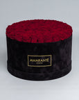 70 Exquisite dark red infinity roses elegantly arranged in a stylish black deluxe suede round rose box. Perfect for expressing timeless love and affection to family, friends and loved ones. Available for free UK delivery.