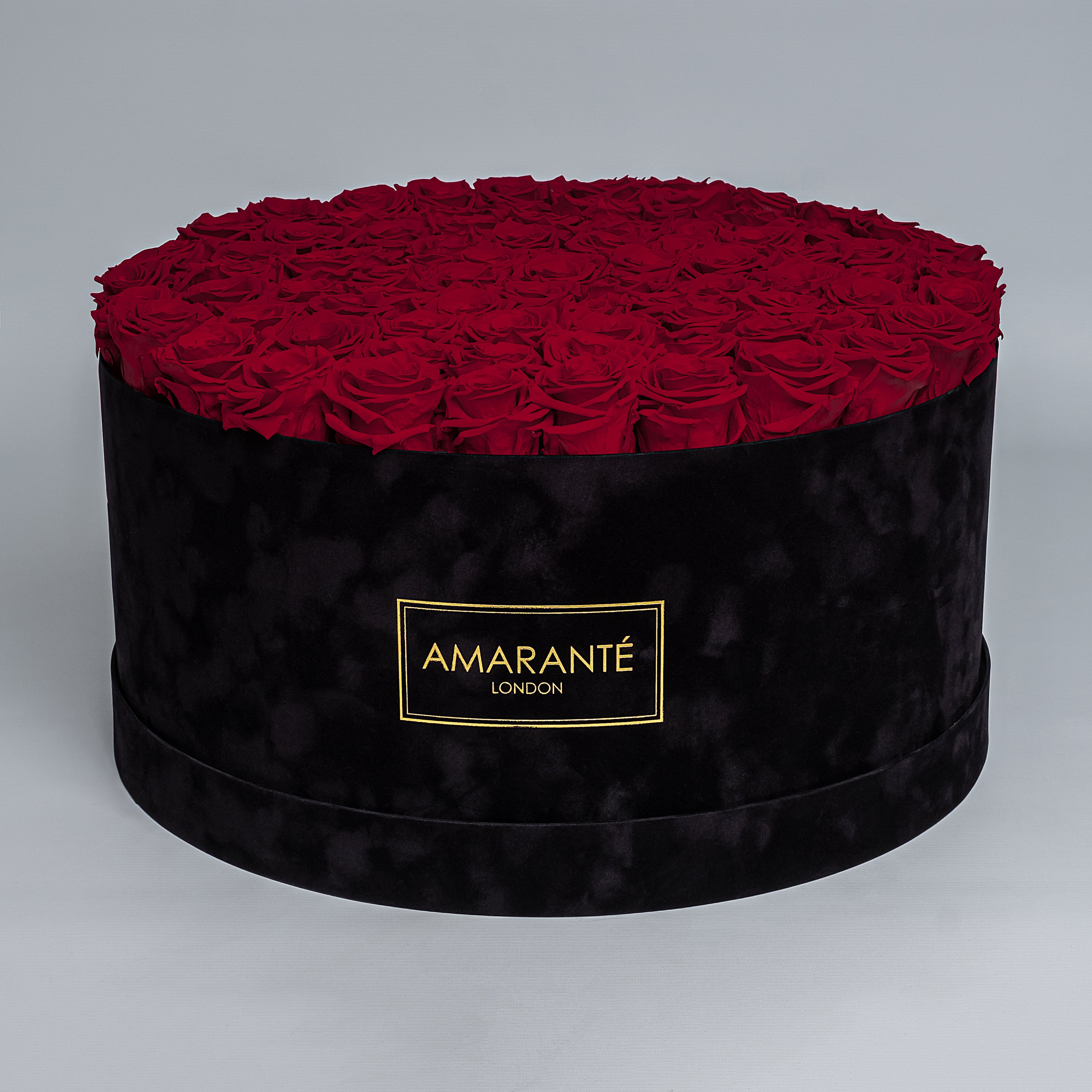 Extra Large Luxury bouquet of 100 deep red infinity roses in an elegant black round rose box with delicate suede finish. Unique gift for showing timeless love and affection. FreeUK Delivery.