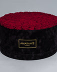 Extra Large Luxury bouquet of 100 deep red infinity roses in an elegant black round rose box with delicate suede finish. Unique gift for showing timeless love and affection. FreeUK Delivery.