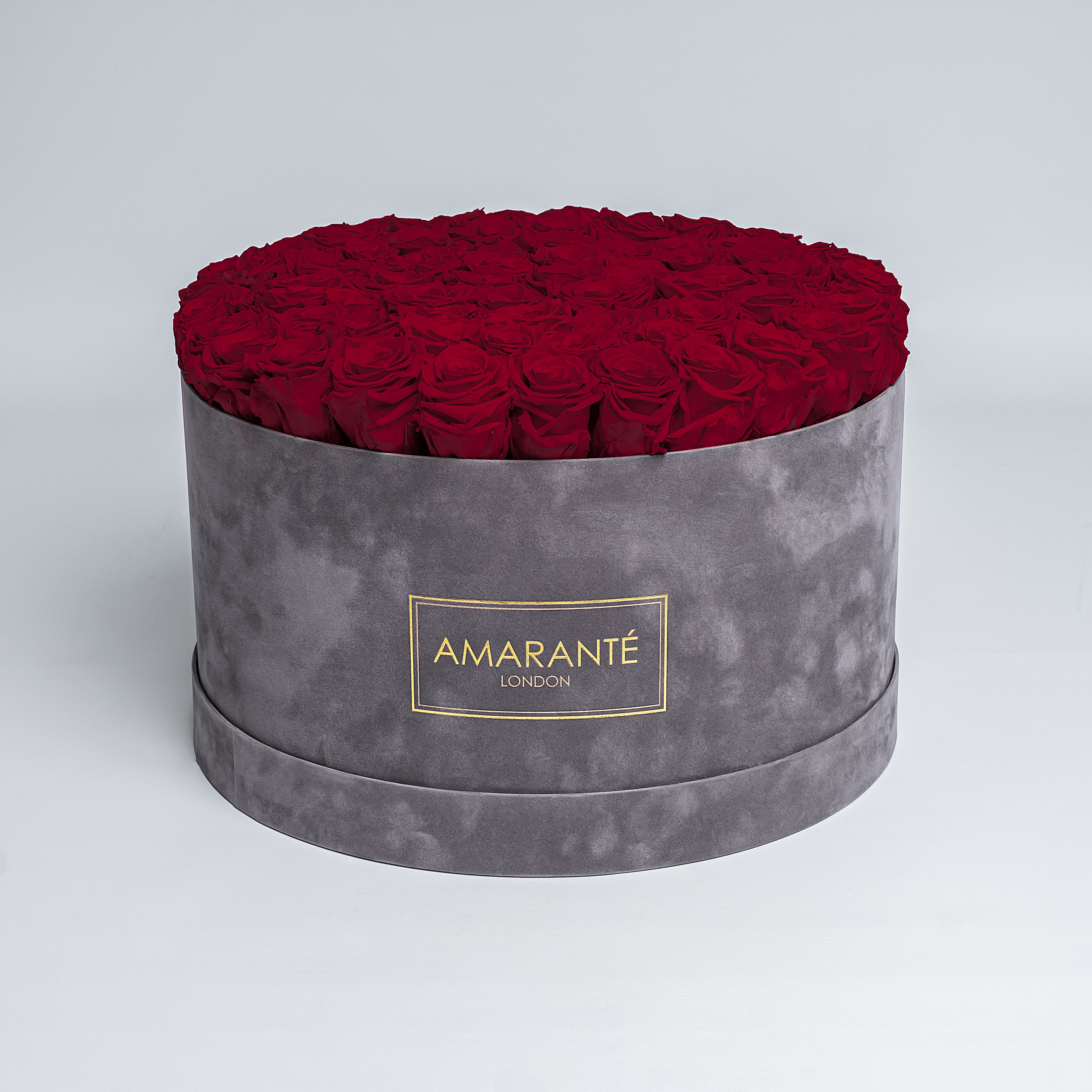 Elegant deep red Infinity Roses artistically arranged in a trendy round grey suede rose box. Free delivery in the UK. A mesmerising, luxurious gift, perfect for showing timeless love and affection to family, friends, or your significant other on Valentine&#39;s Day, Birthday, Anniversary, or other important occasion.