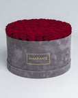 Elegant deep red Infinity Roses artistically arranged in a trendy round grey suede rose box. Free delivery in the UK. A mesmerising, luxurious gift, perfect for showing timeless love and affection to family, friends, or your significant other on Valentine's Day, Birthday, Anniversary, or other important occasion.