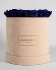 Luxurious royal blue roses feature din a delicate beige medium box. 