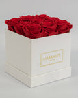 Divine red roses entrenched in a dapper white medium hatbox in square 