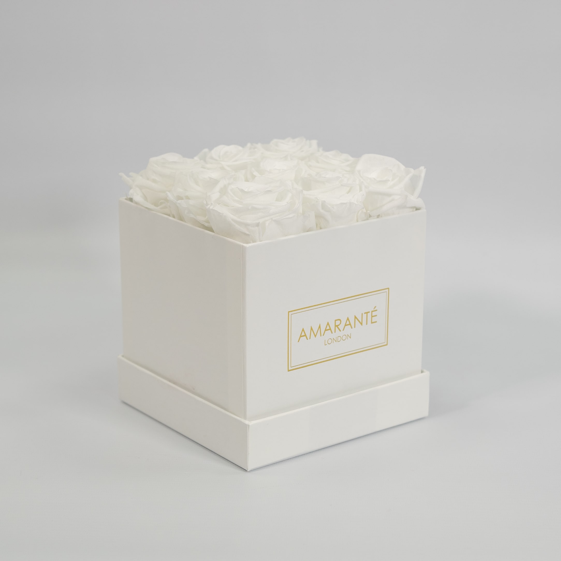 Enchanting white roses featured in a monochromatic white box 