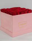 Aromatic red roses bursting with fiery shades in a blushing pink box  