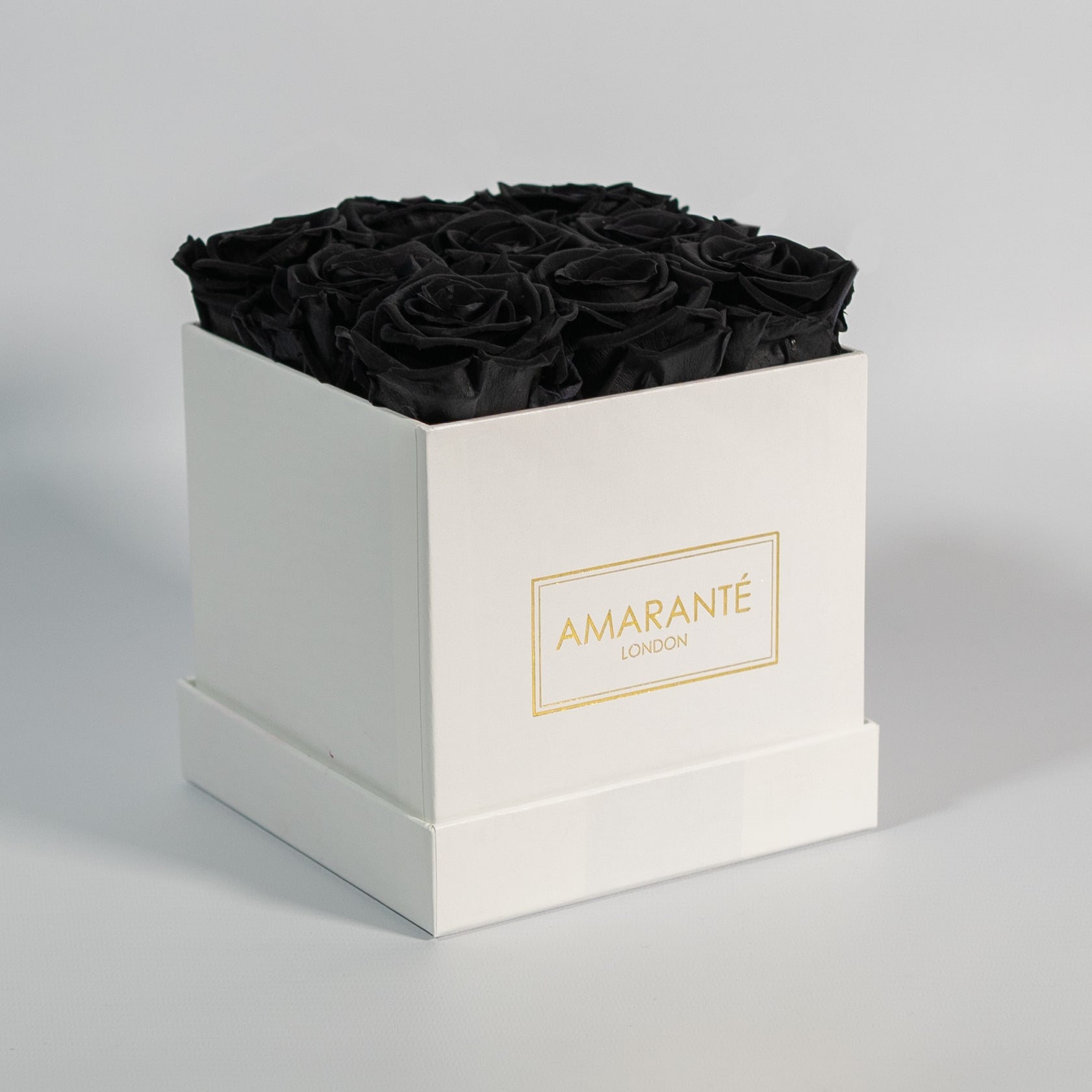 Bold black roses imbedded in a captivating white box 
