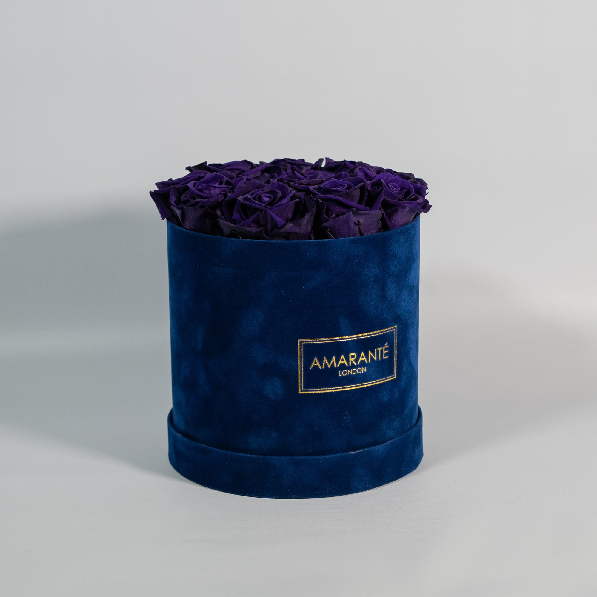 Luxurious dark purple Roses showcased in a dapper blue box 
