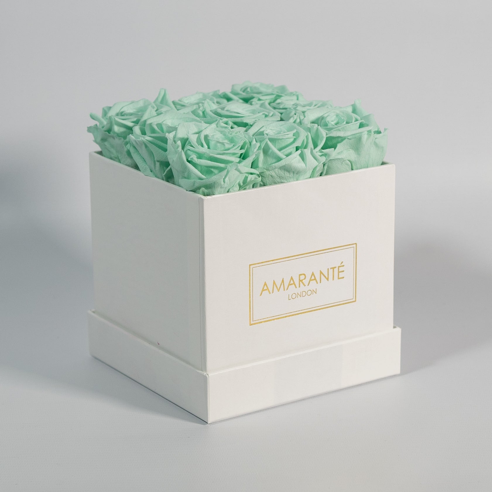 Elegant mint green roses presented in a fashionable white box 