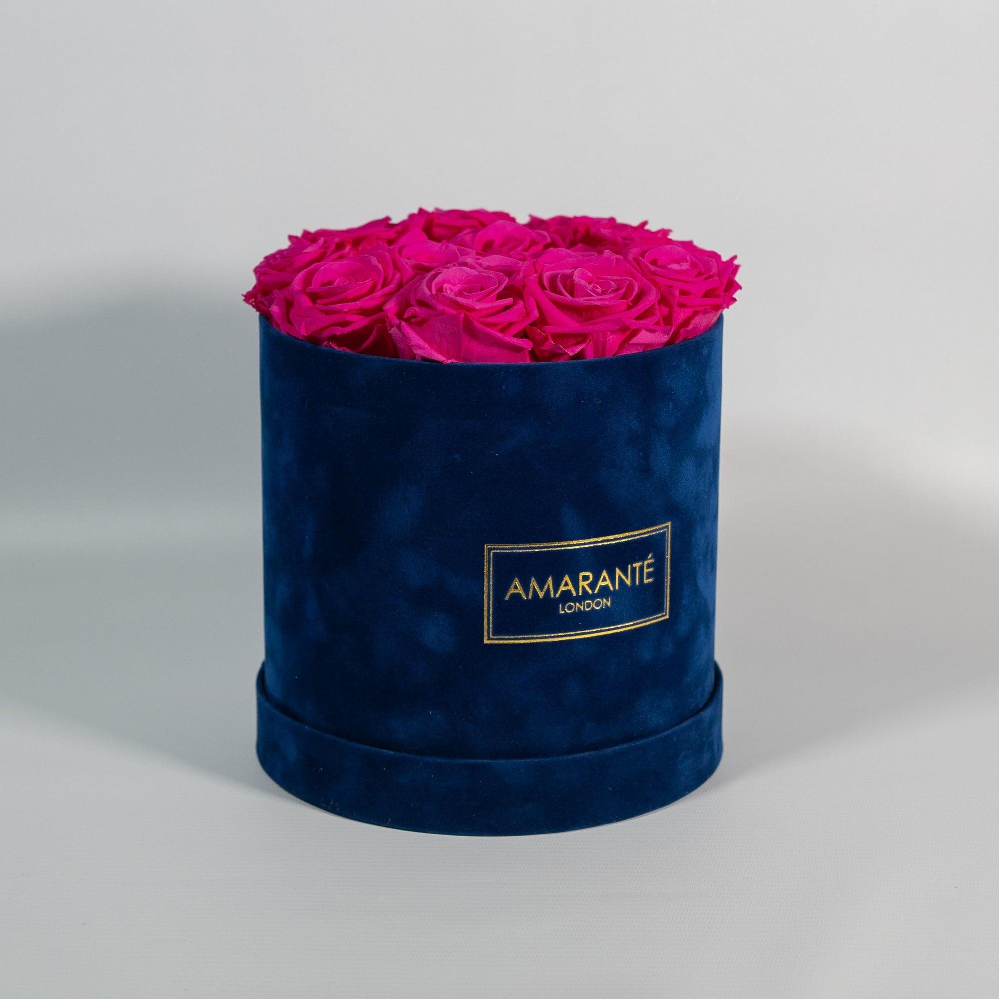 Expressive hot pink Roses shown in a beautiful blue box 