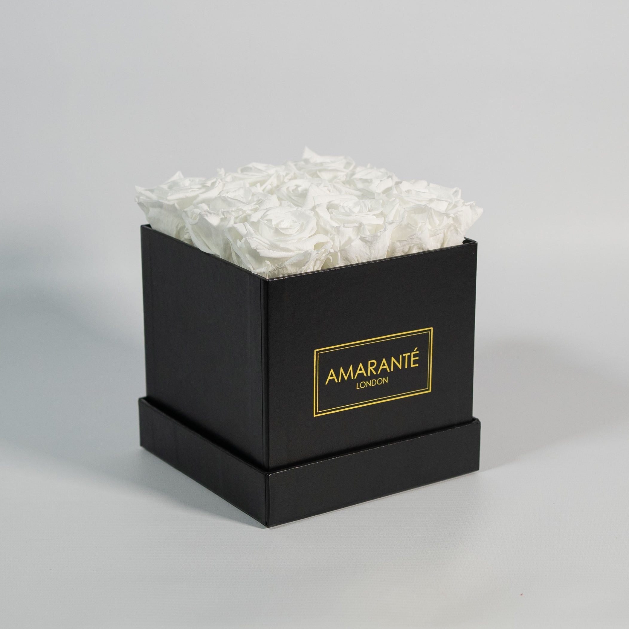 Captivating white roses entrenched in a modish black box 