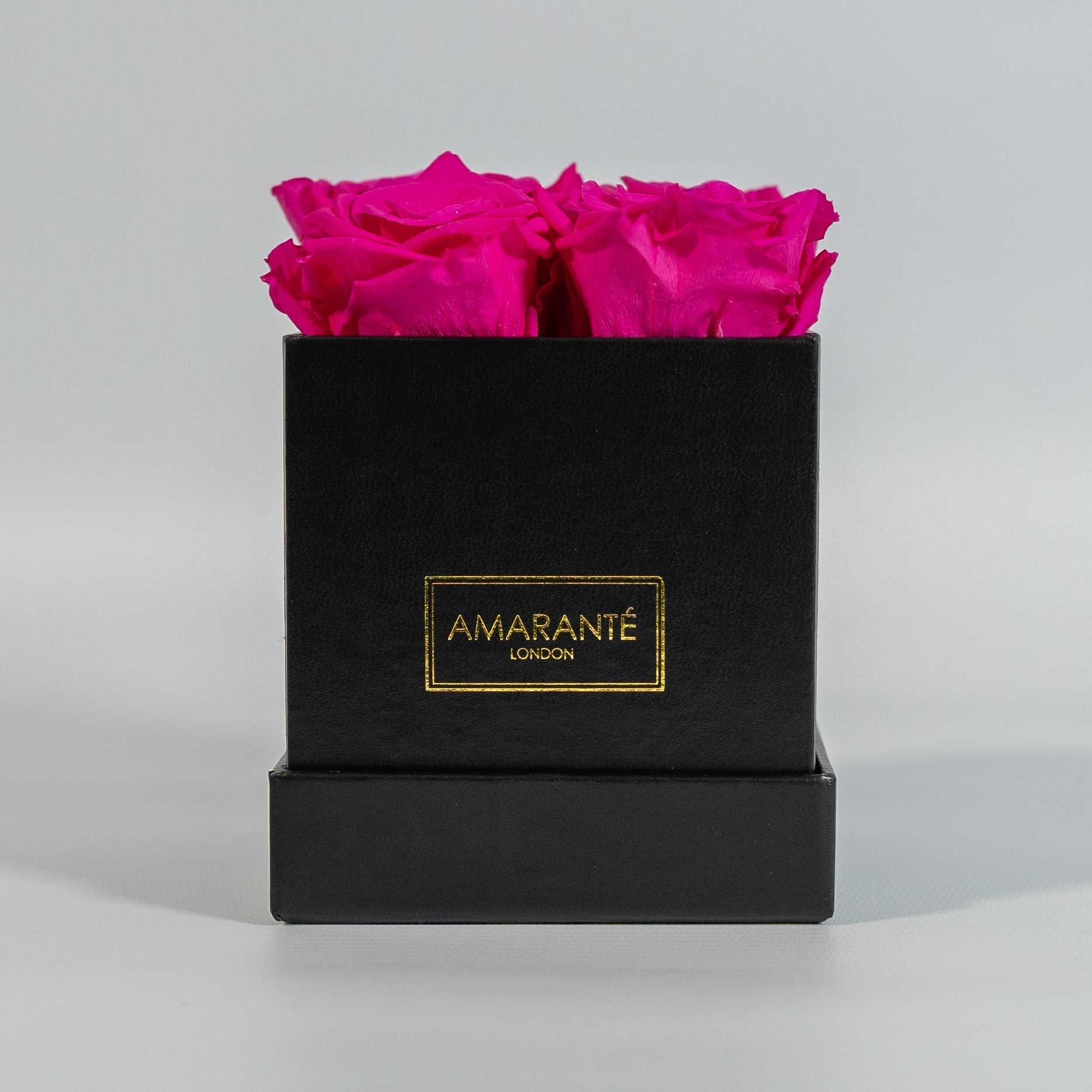Distinctive hot pink roses shown in a stylish black box  