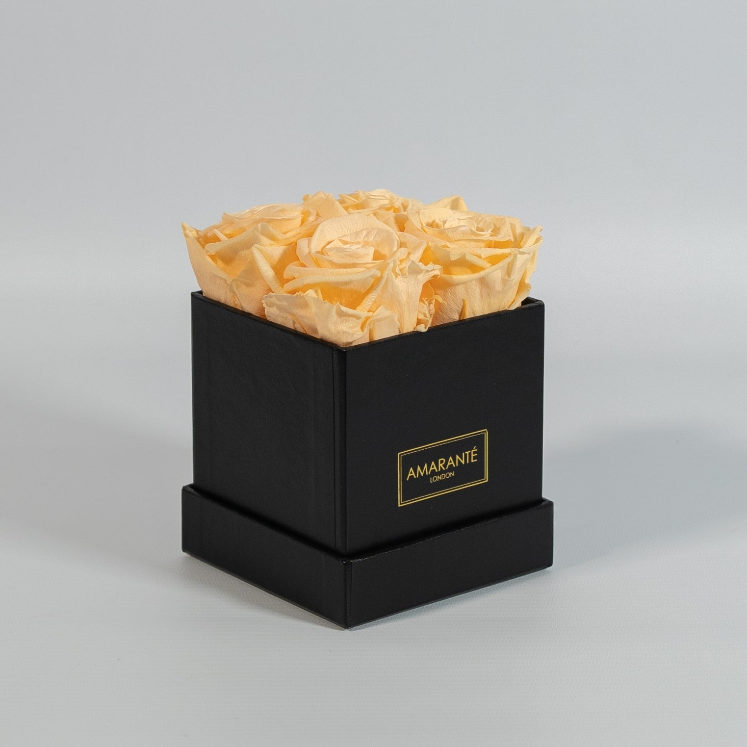 Summer inspired peach roses placed in a modish black box 