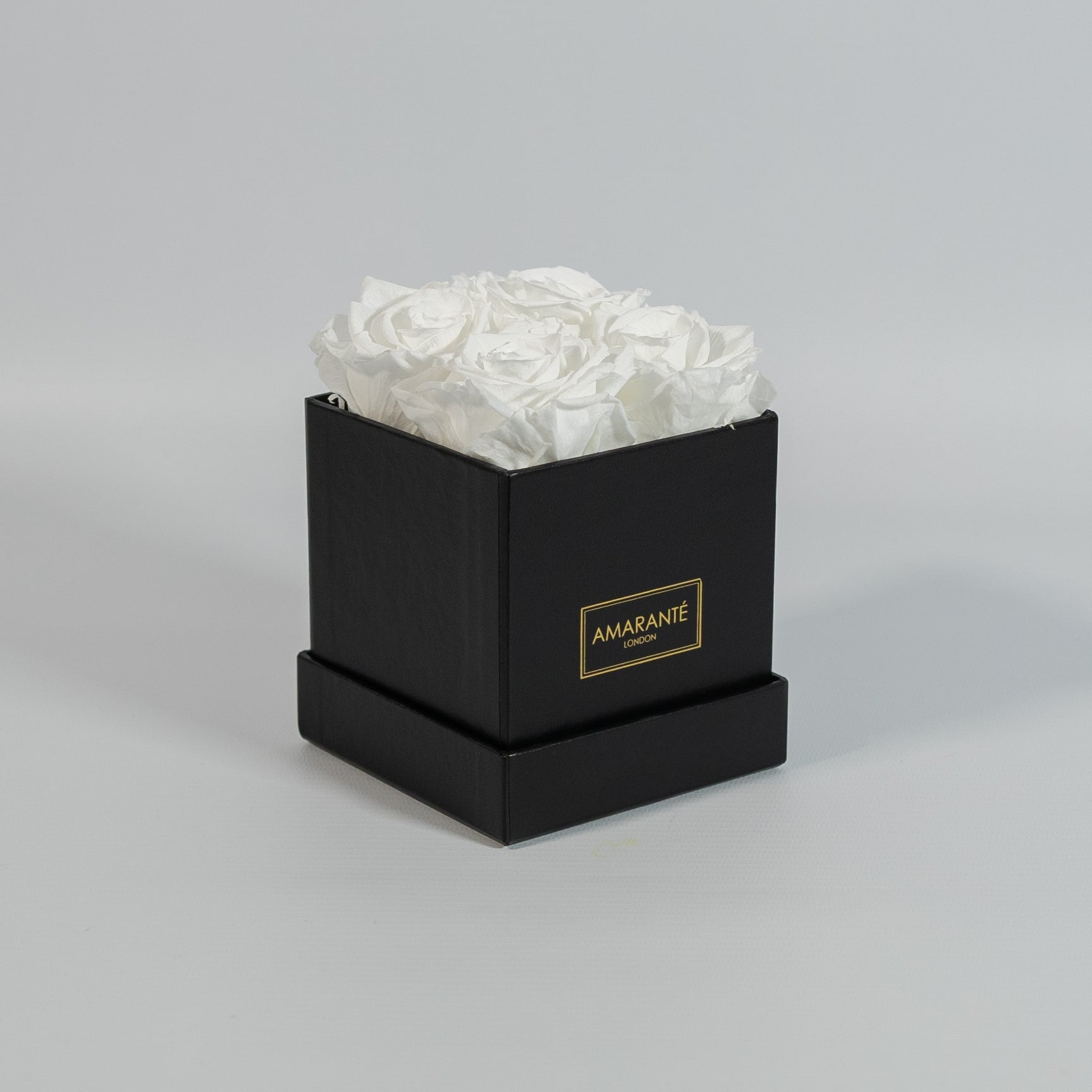 Captivating white roses placed in a vogueish black box 