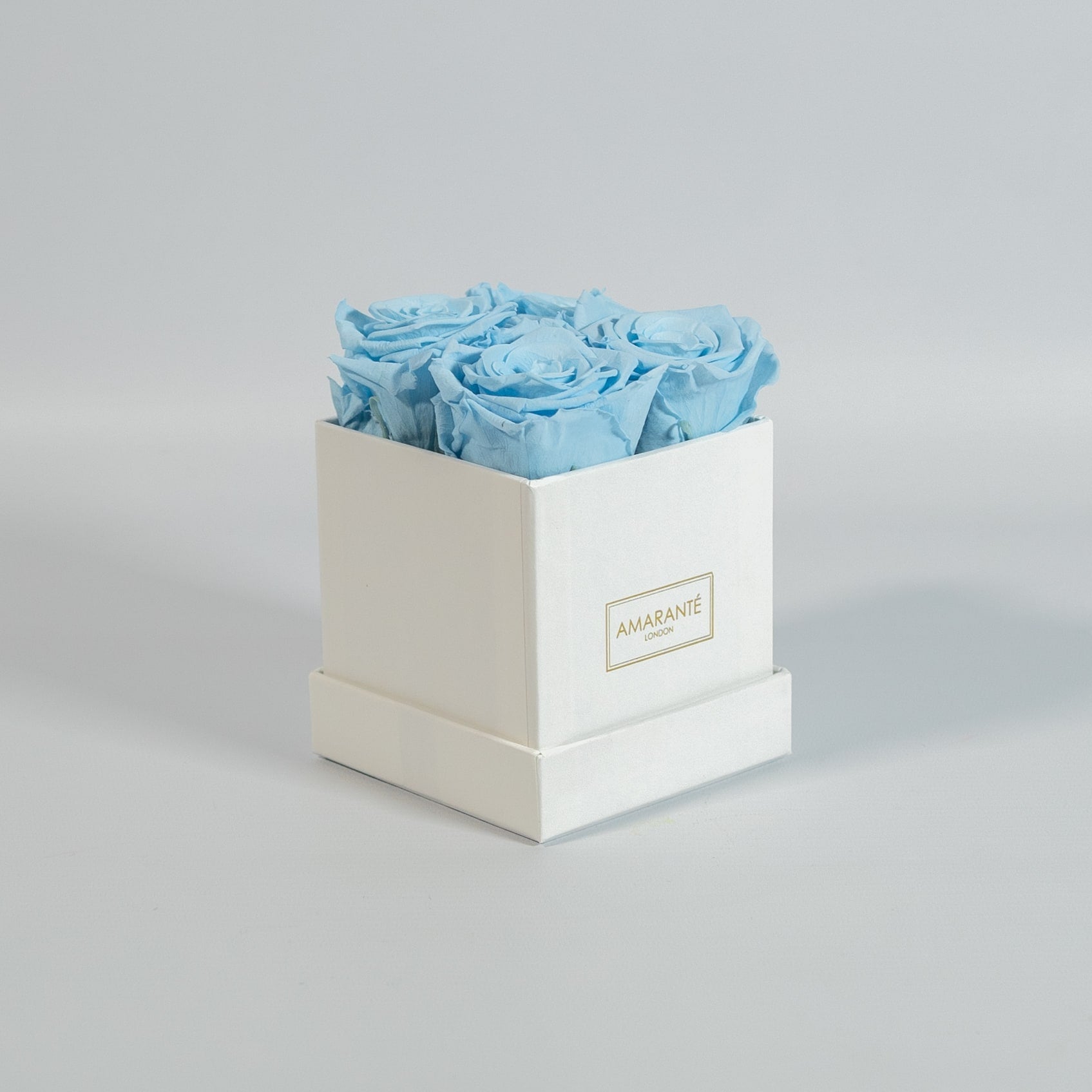 Cool light blue roses featured in a stylish white box 