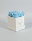 Cool light blue roses featured in a stylish white box 
