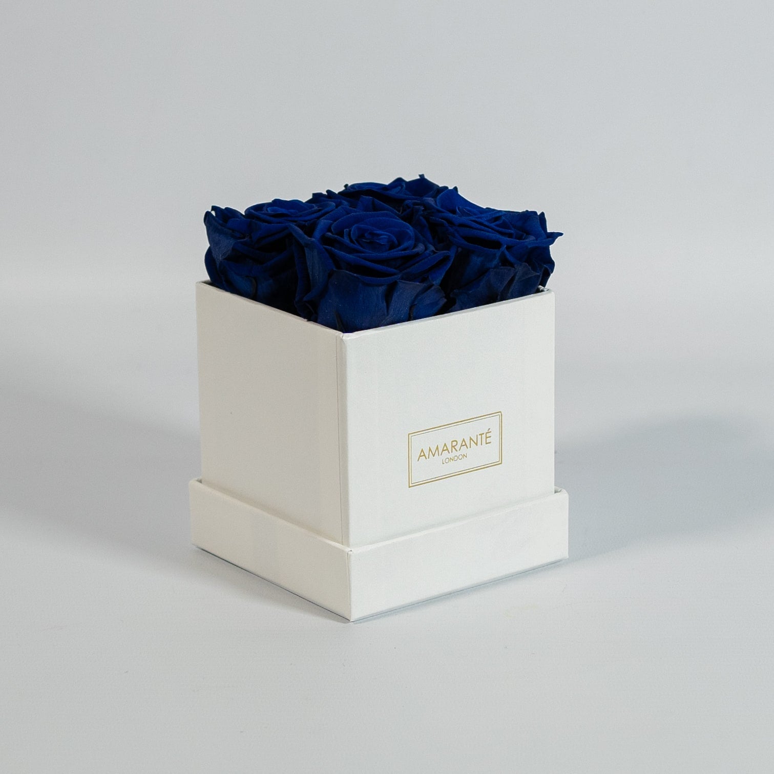 Magical royal blue roses imbedded in a charming white box 