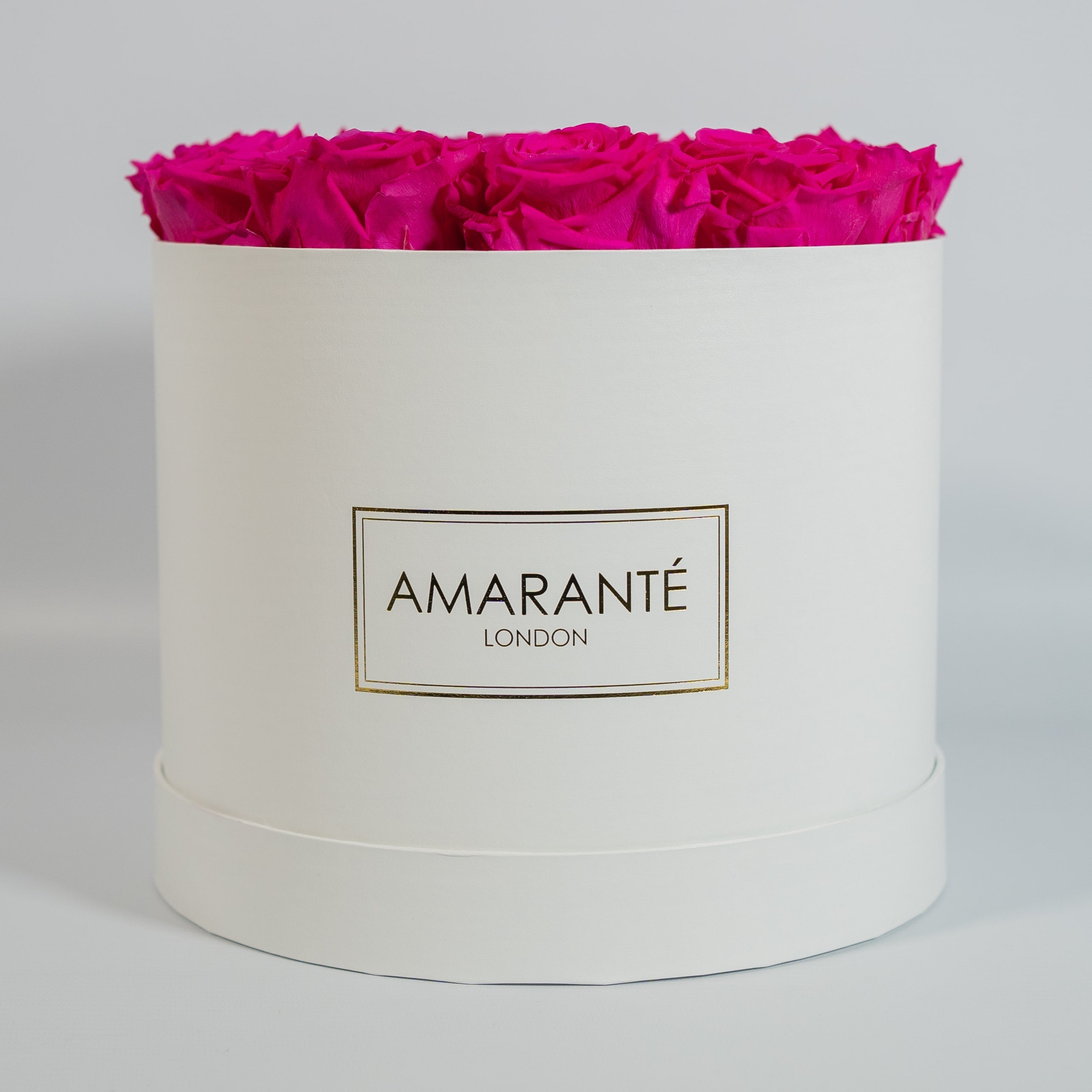 Expressive hot pink Roses featured in a dapper white box 