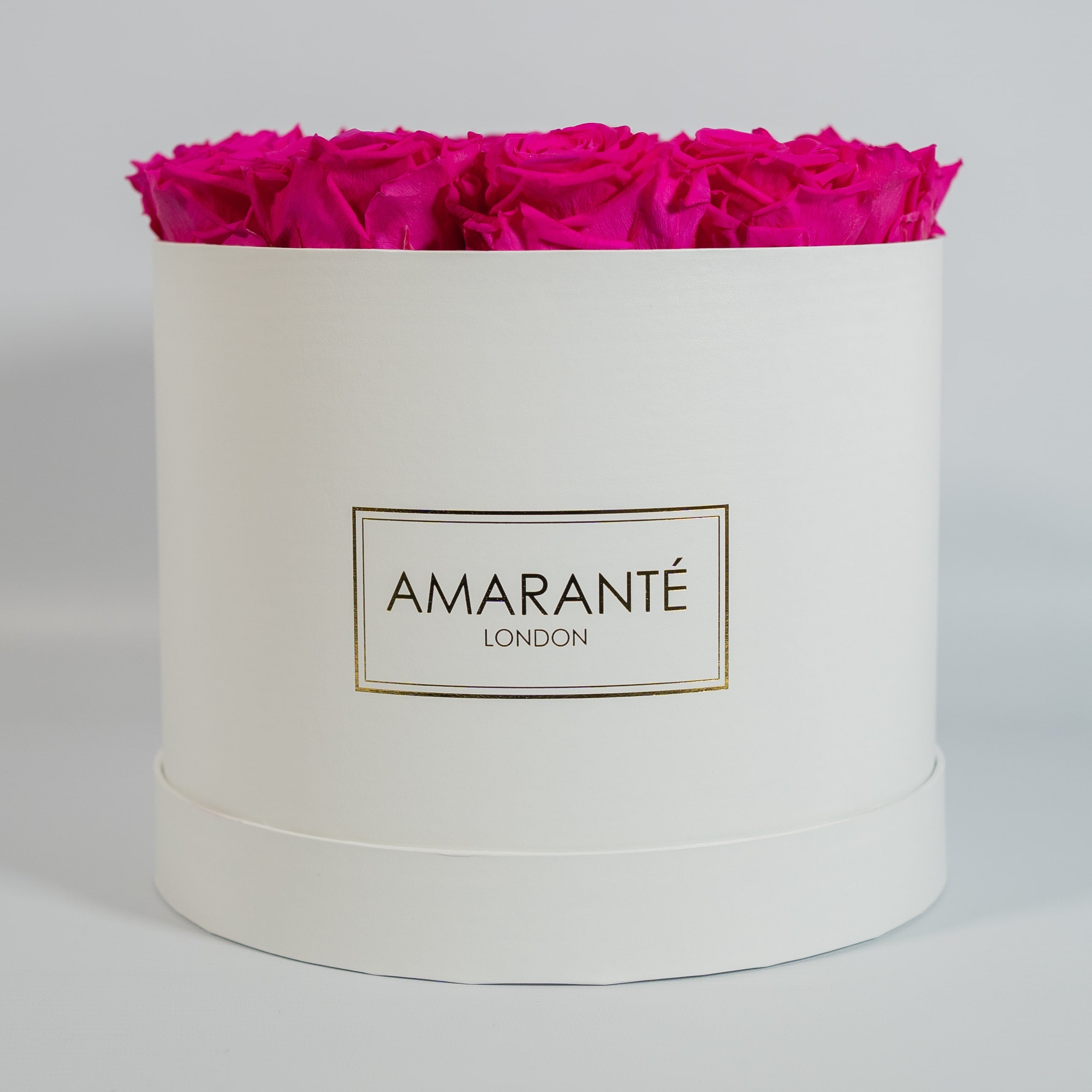 Expressive hot pink Roses featured in a dapper white box 