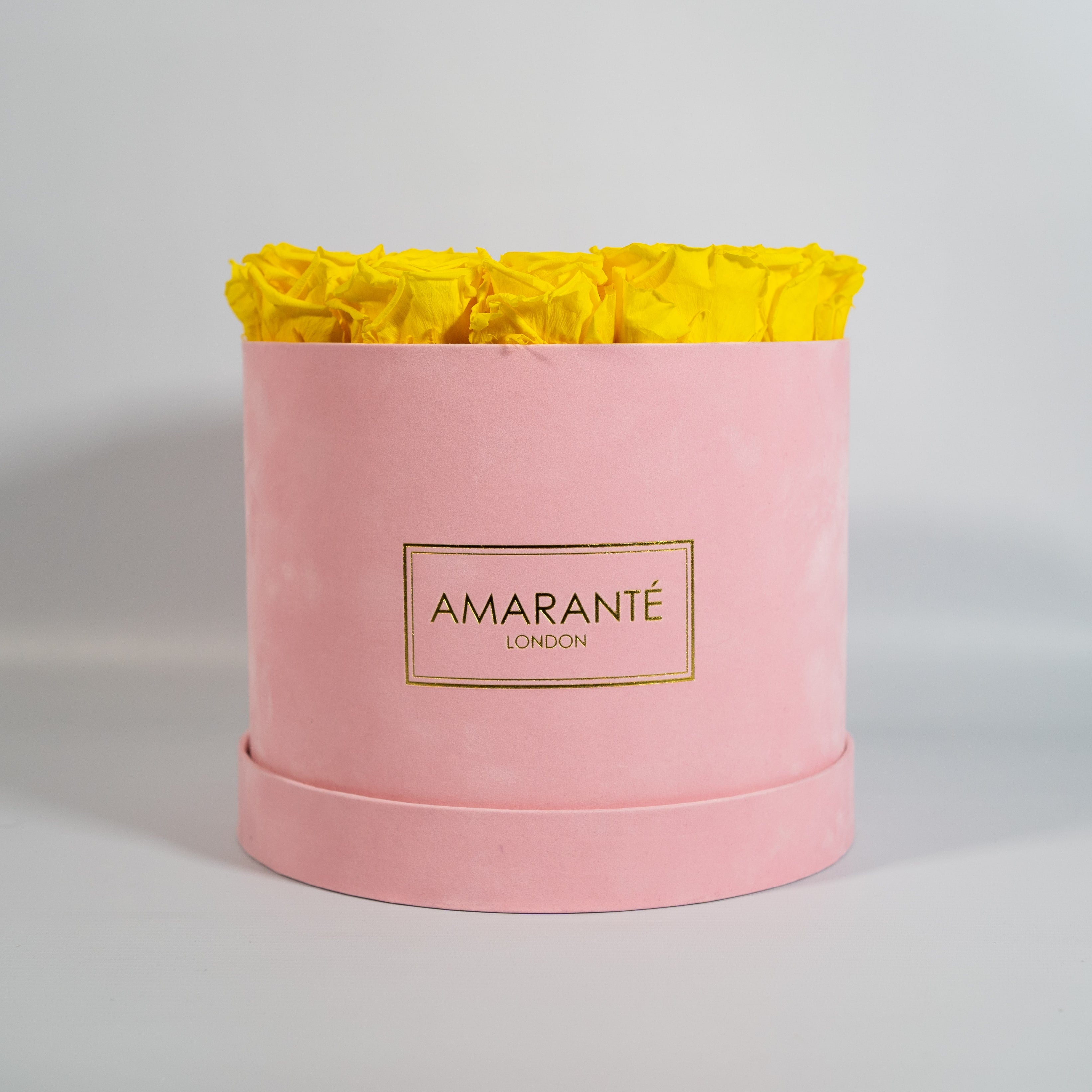 Delightful yellow Roses in a vogueish pink suede box