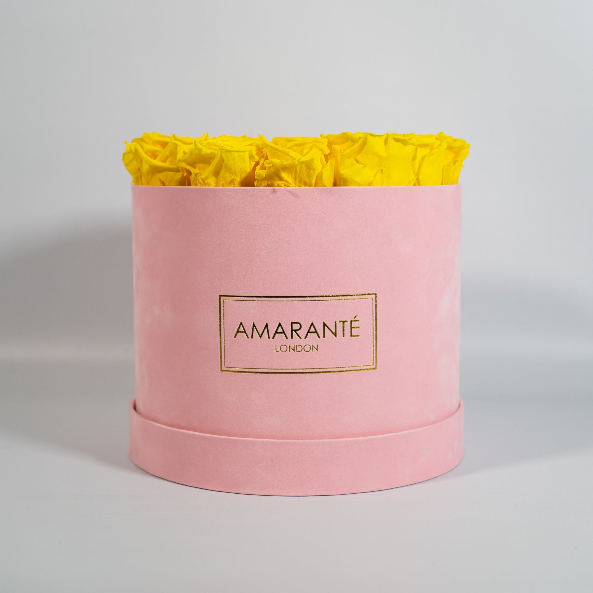 Delightful yellow Roses in a vogueish pink suede box
