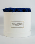 Artistic royal blue Roses displayed in a captivating white box.  