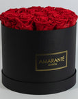 Majestic red Roses displayed in a dapper black large round hatbox 