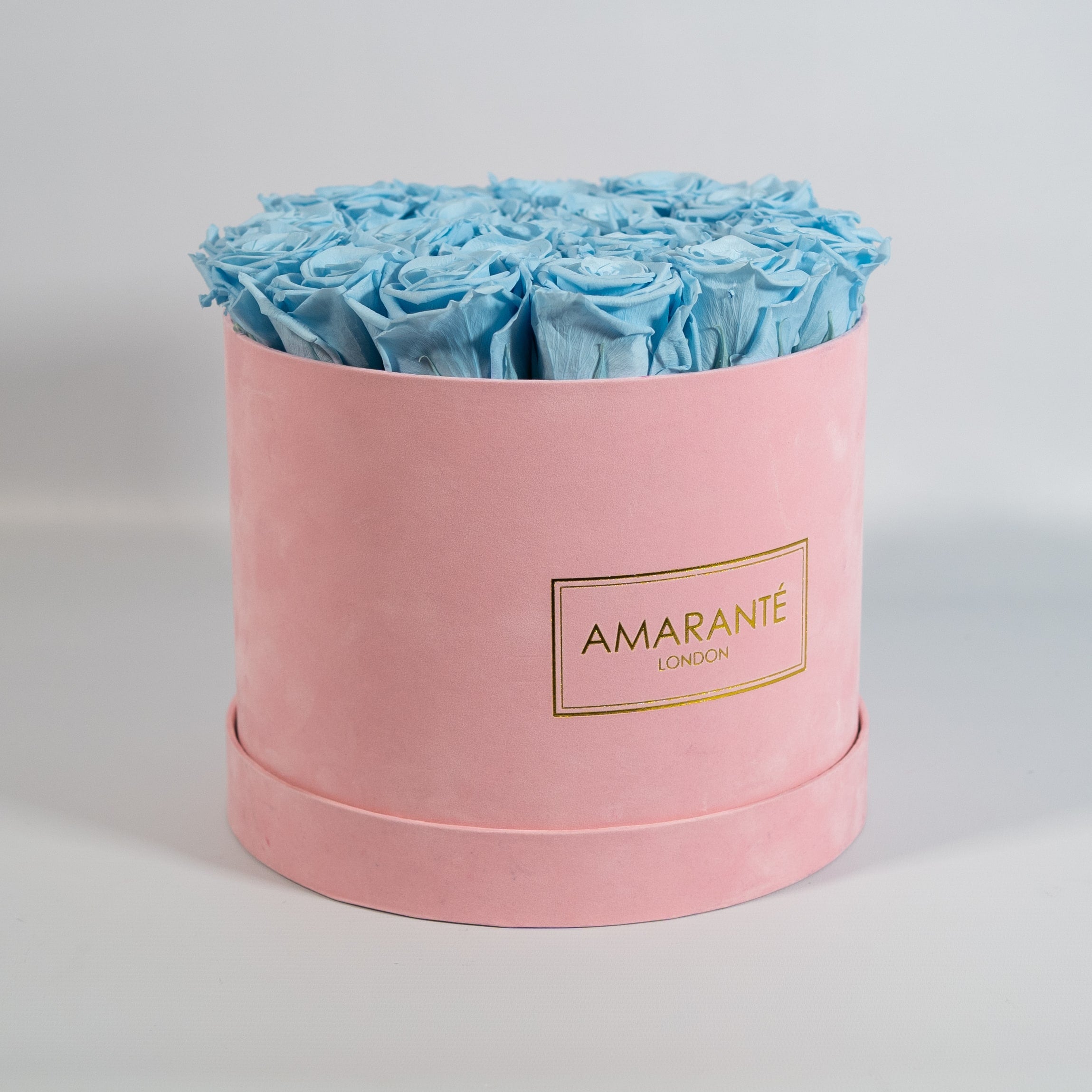 Delicate light blue Roses encompassed in a blushing pink box 