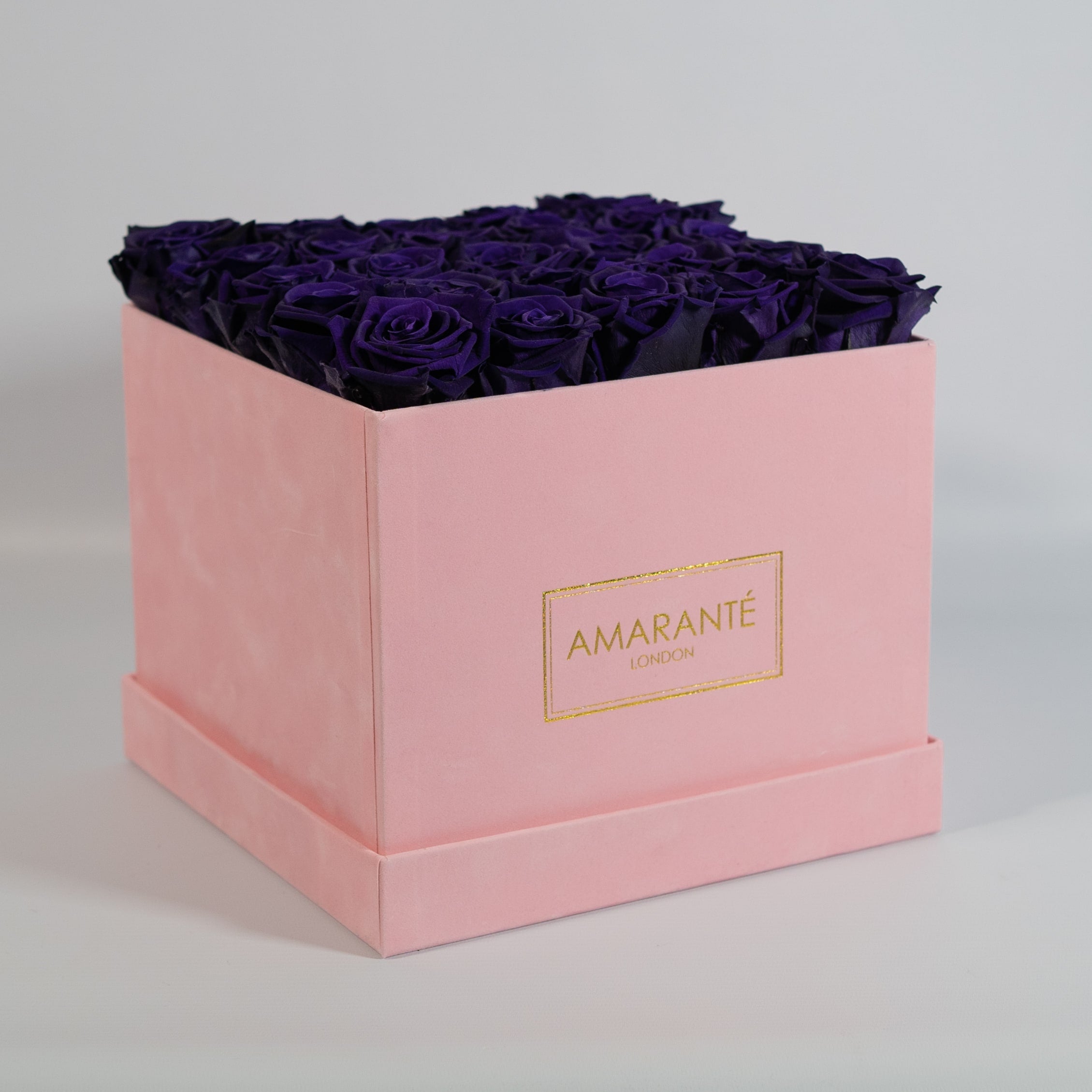 Luxurious dark purple roses exhibited in a stylish pink box 