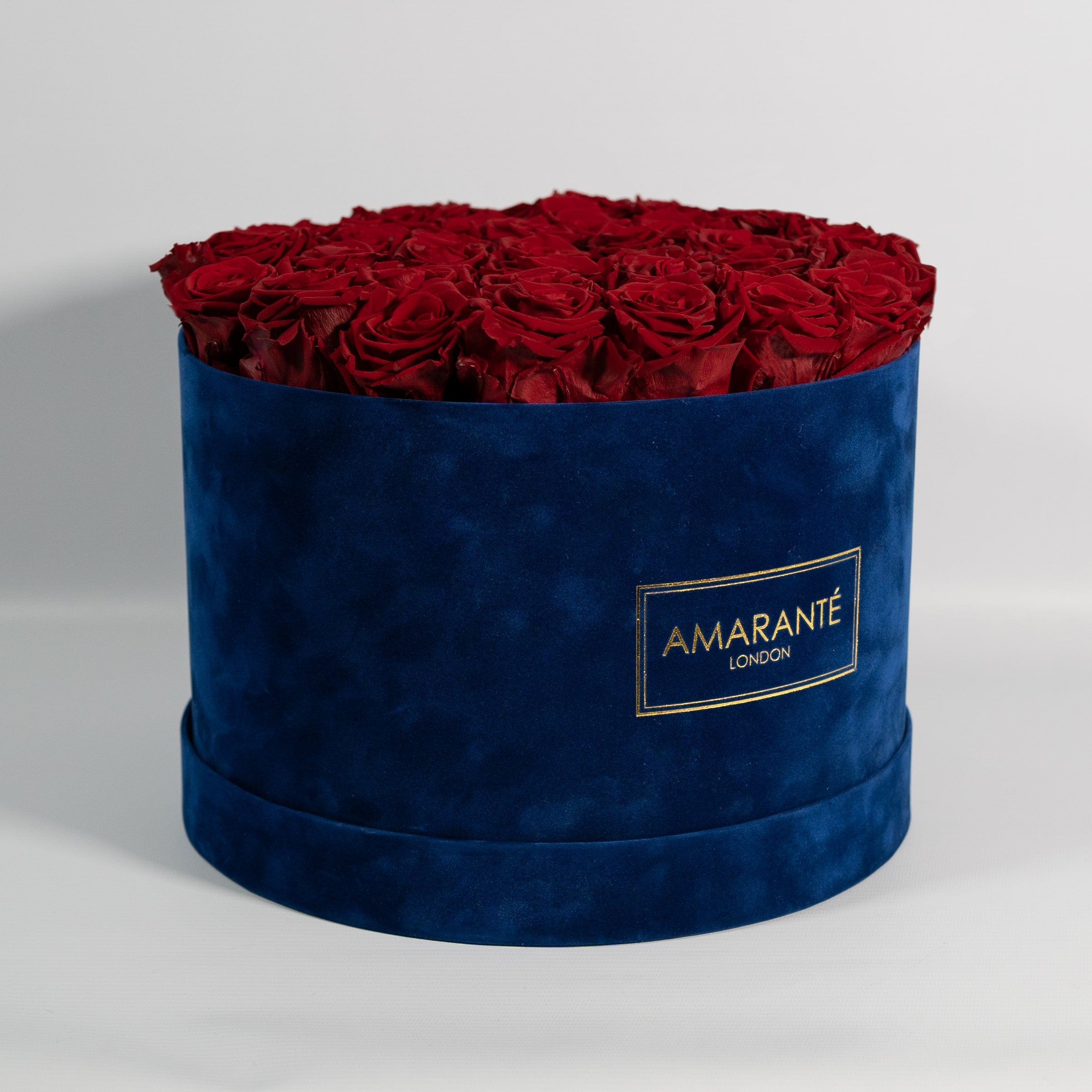 Fragrant dark red roses in a dapper blue package. 