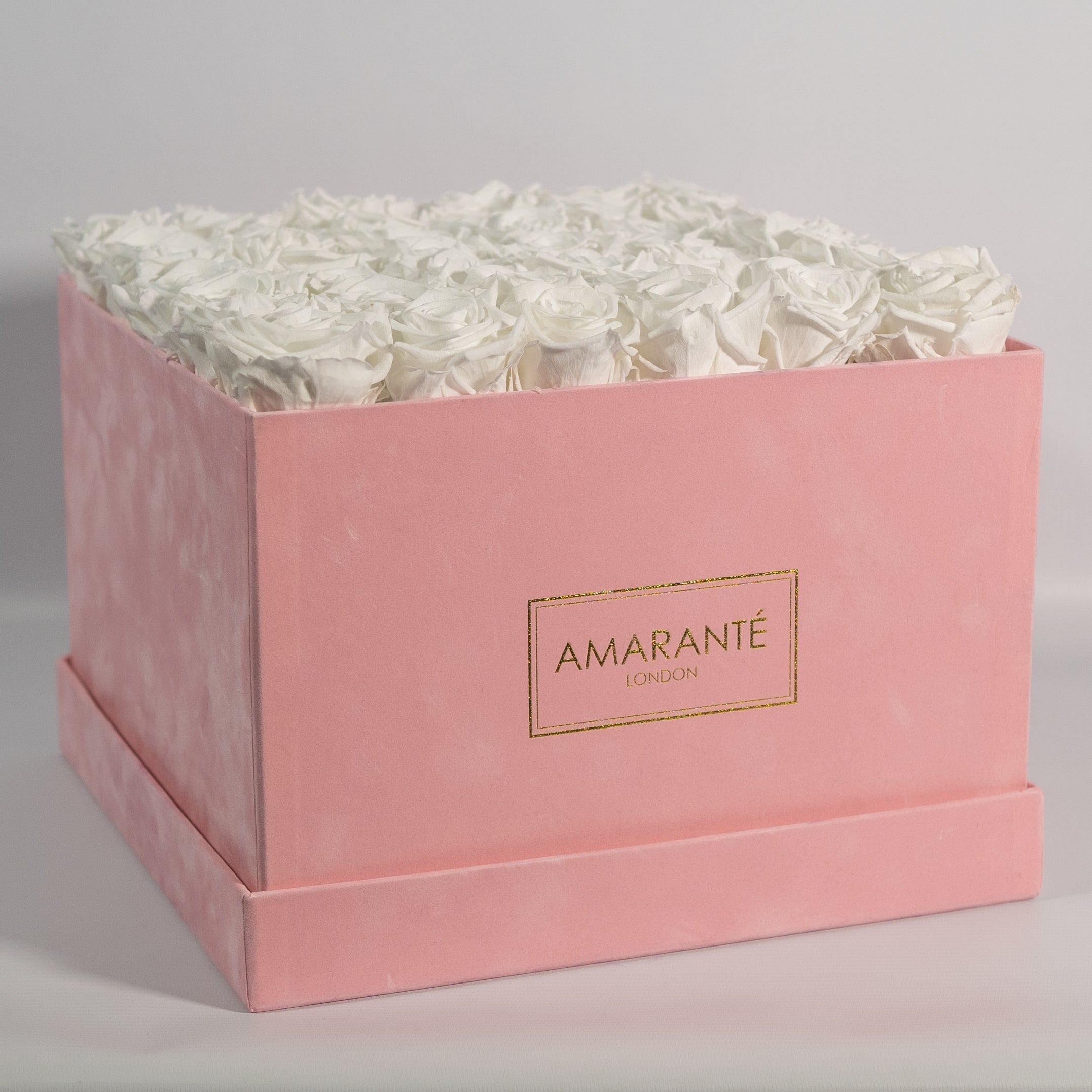 Captivating white roses displayed in a magical pink box 
