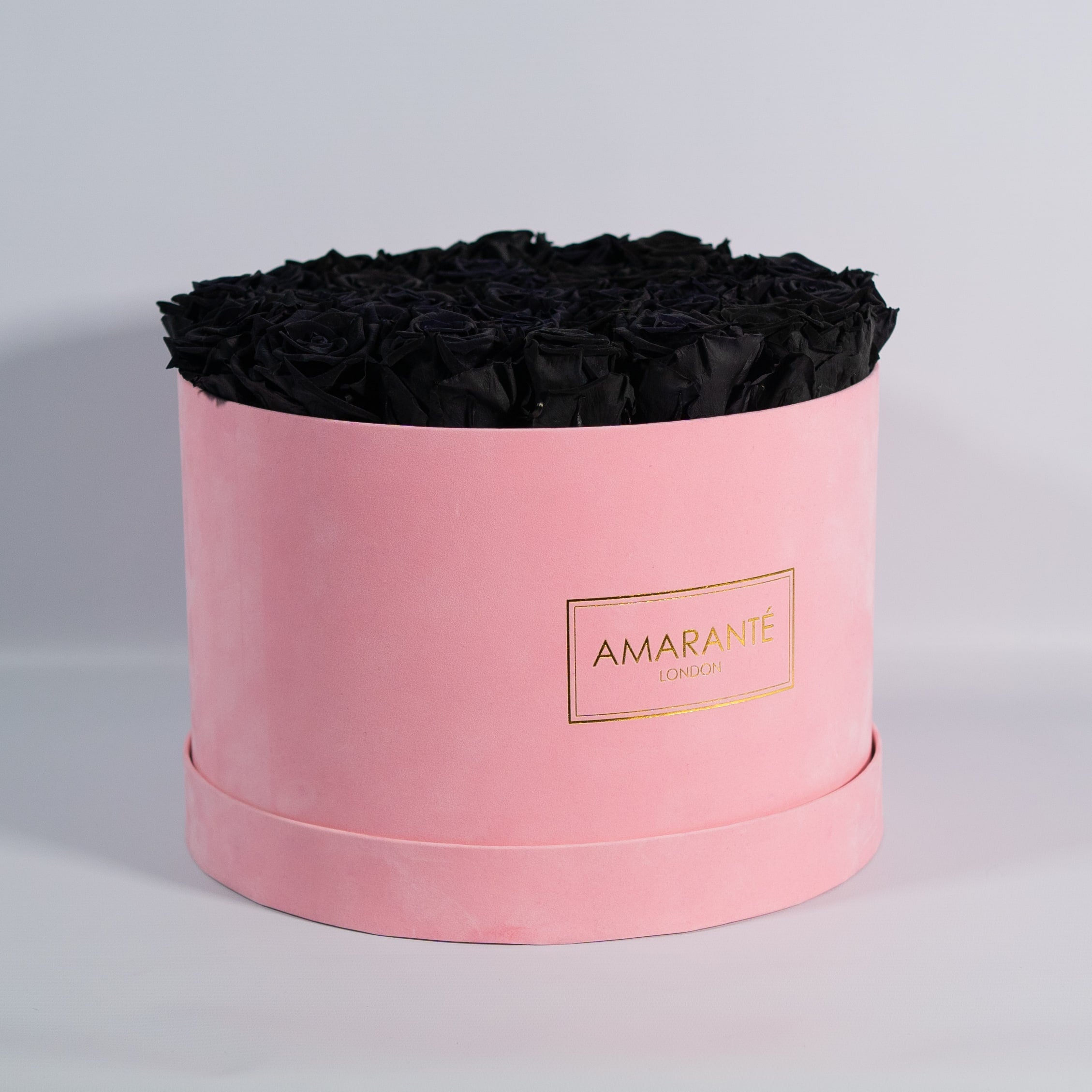 bold black Roses in a dapper pink suede box 