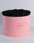 bold black Roses in a dapper pink suede box 