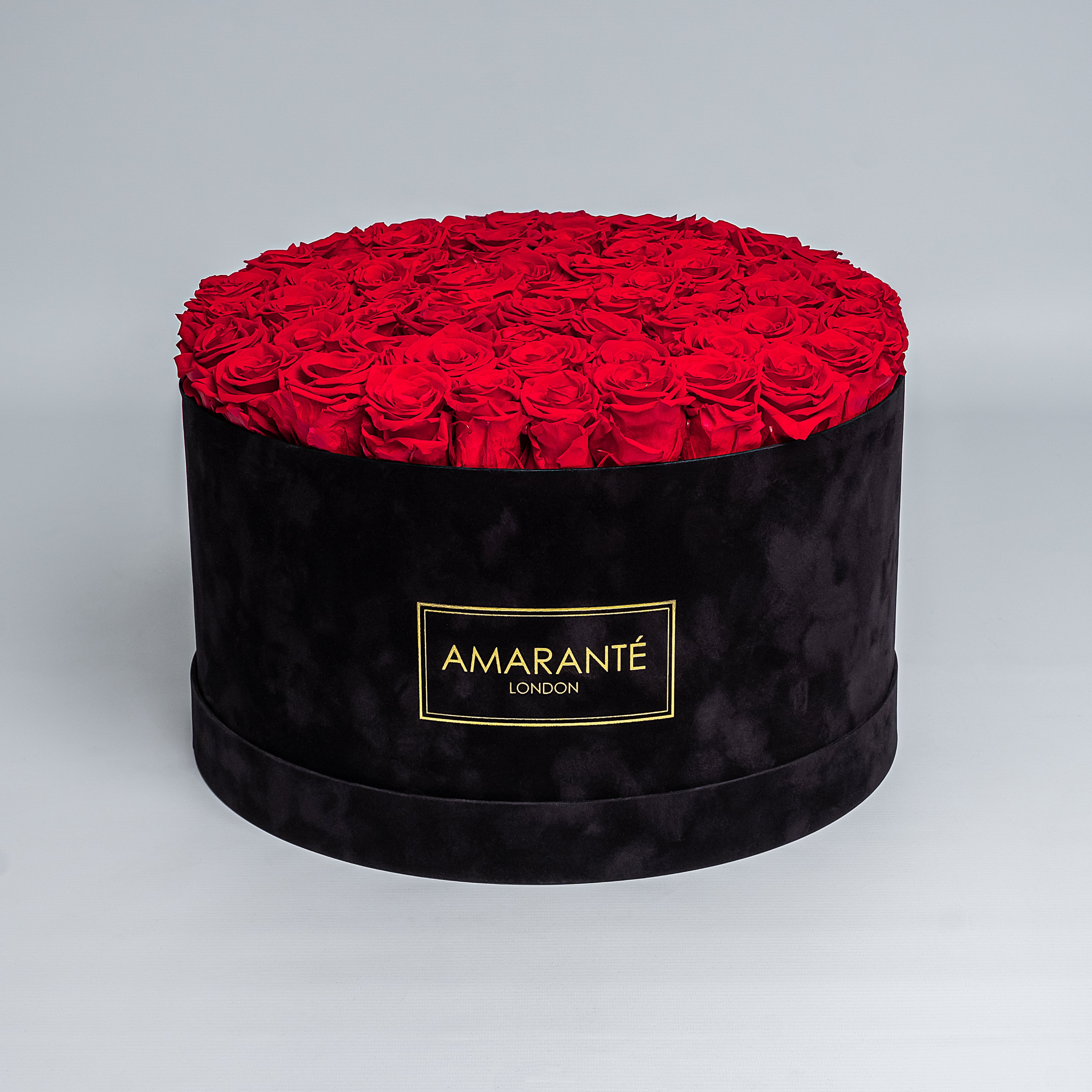 70 Exquisite bright red infinity roses elegantly arranged in a stylish black deluxe suede round rose box. Perfect for expressing timeless love and affection to family, friends and loved ones. Available for free UK delivery.