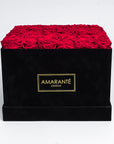 36 Bright red infinity roses elegantly placed in an extra large black suede hatbox. Free UK Delivery.