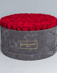 Mesmerising bouquet of 100 light red infinity roses nestled in a grey round rose box with delicate suede finish. Exquisite gift for showing timeless love and affection. FreeUK Delivery.