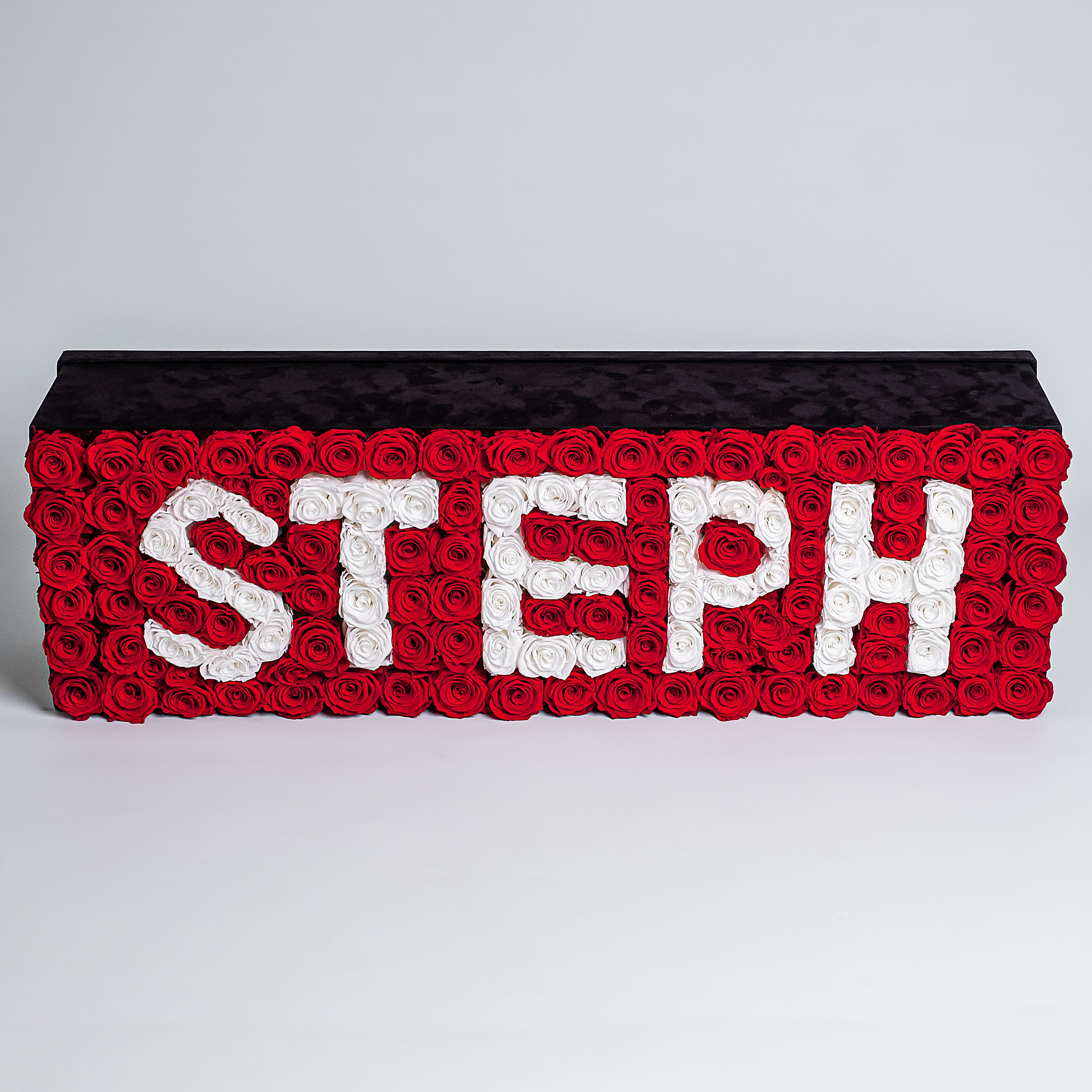 Frontal view of super deluxe black rectangular rose box 30&quot;x25&quot;, housing 140 red and white infinity roses, symbolising enduring love with the name STEPH. Free UK delivery.